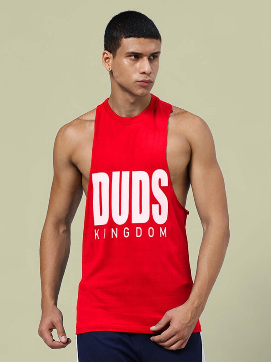 Man wearing DUDS KINGDOM red gym t-shirt, showcasing sleeveless design, perfect for workouts, available with custom fit option on prepaid orders.