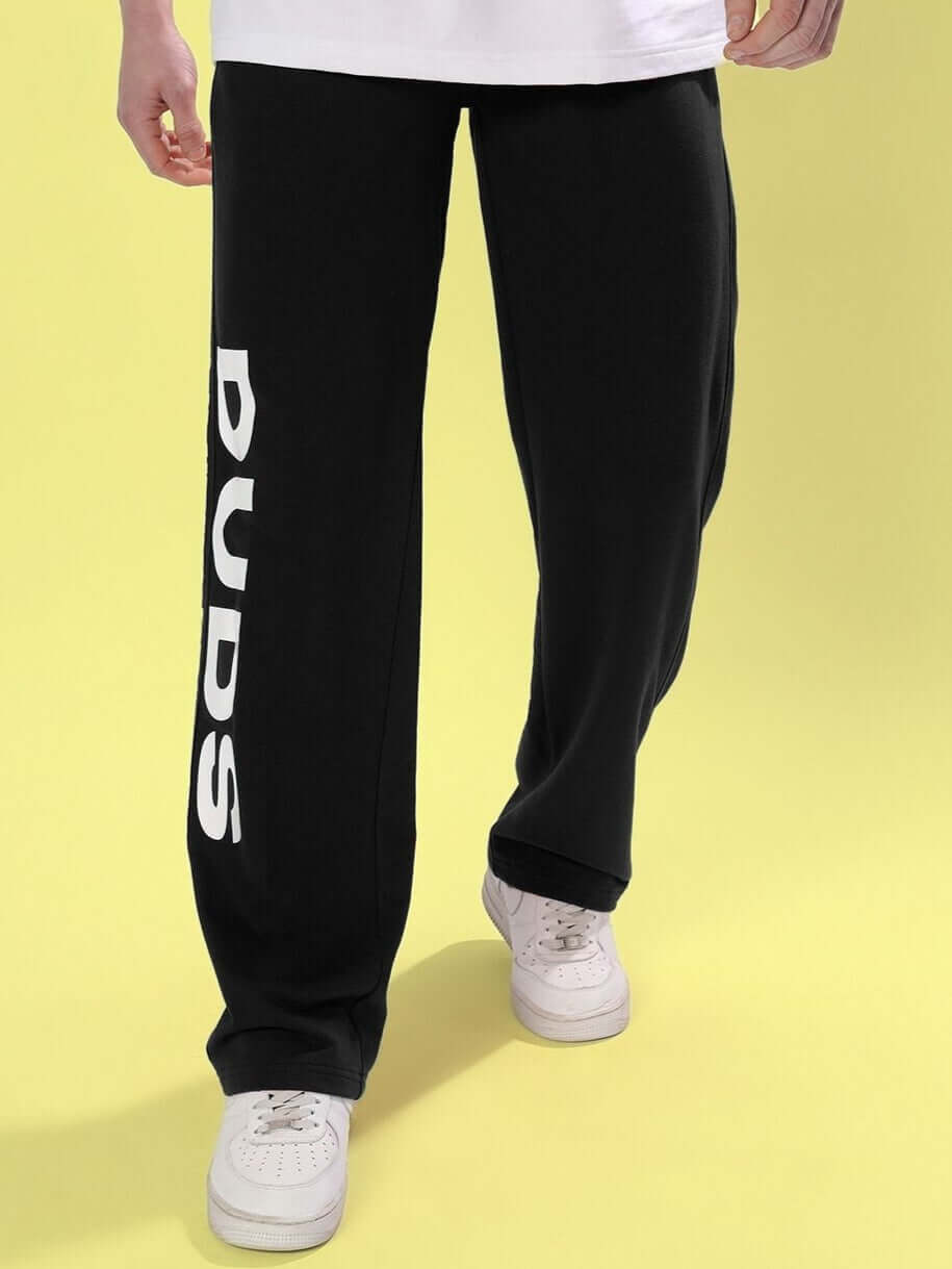 Black DUDS Limited Edition Jogger with logo on leg, perfect for custom fit options and made-to-order craftsmanship, shown on yellow background.