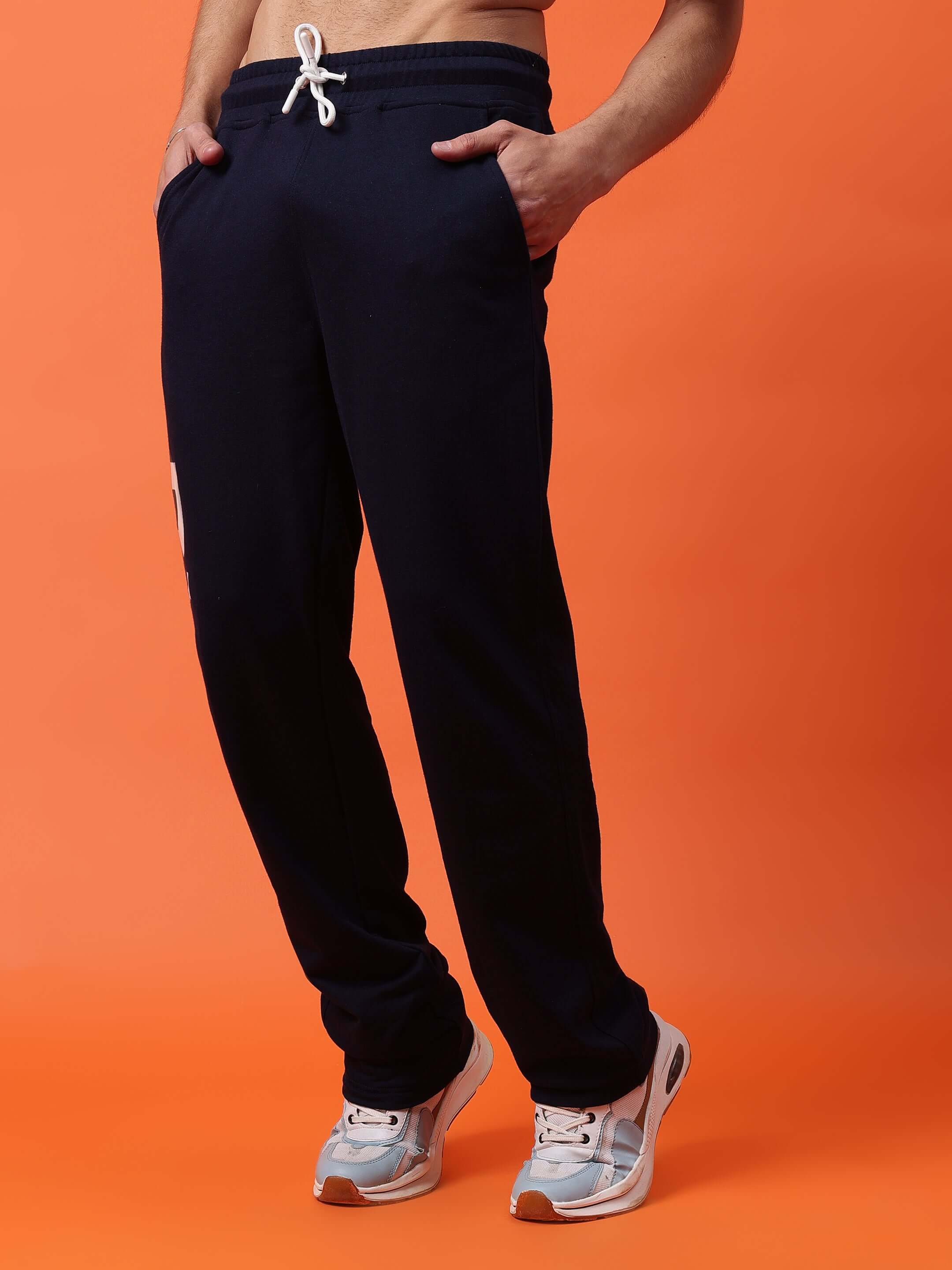 Limited edition navy blue jogger pants by DUDS, tailored for comfort and style, shown on model against an orange background.