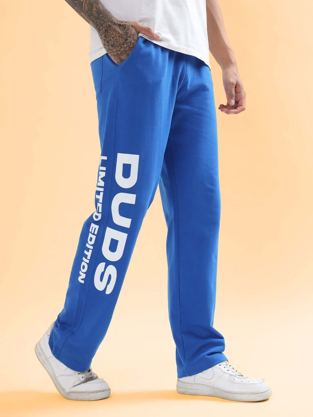 Man wearing DUDS Limited Edition Royal Blue Jogger with bold lettering, showcasing stylish and comfortable custom-fit fashion.