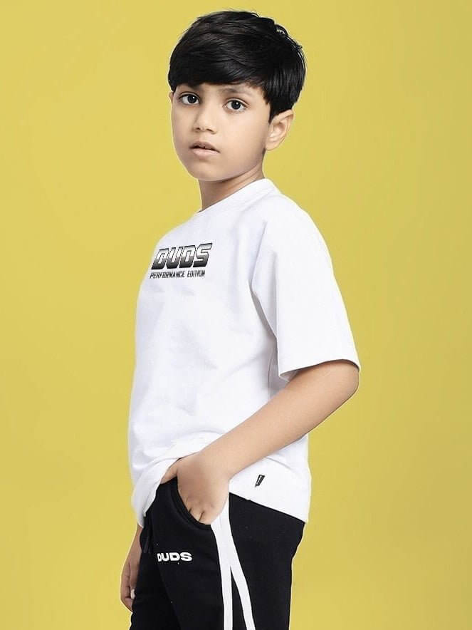 Boy wearing DUDS PERFORMANCE T-SHIRT FOR BOYS AND GIRLS WHITE with logo detail against yellow background, ideal for active kids.