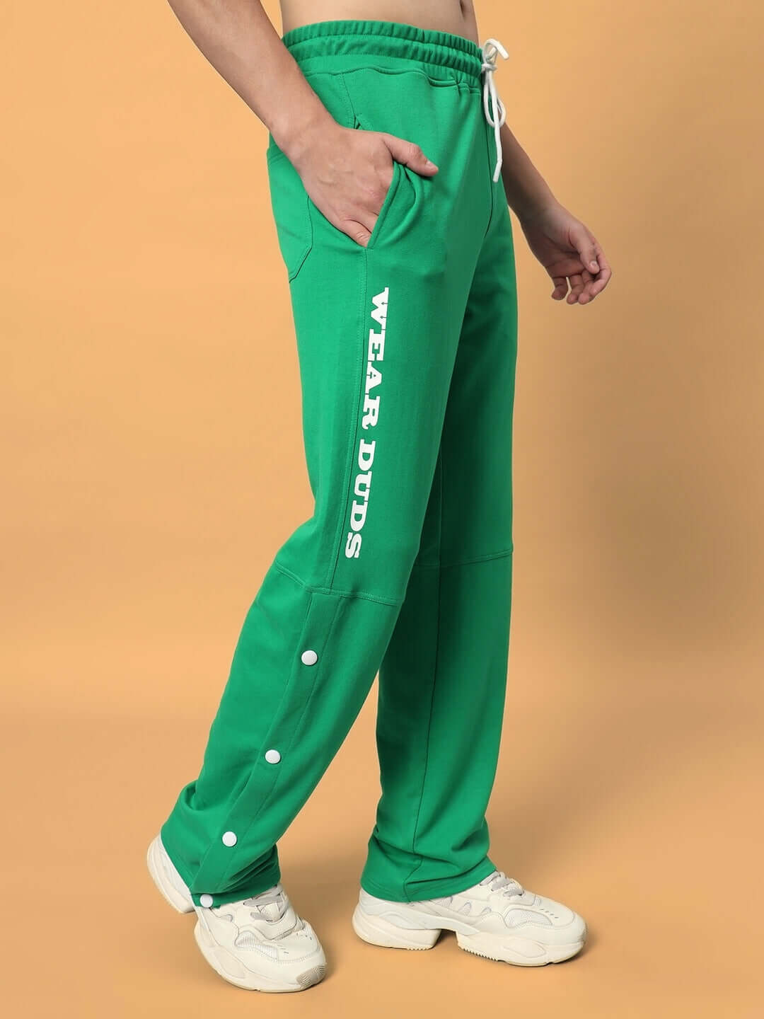 Man wearing DUDS Racer Joggers in green with side pockets and 'Wear DUDS' logo, customizable fit available, made to order by DUDS.