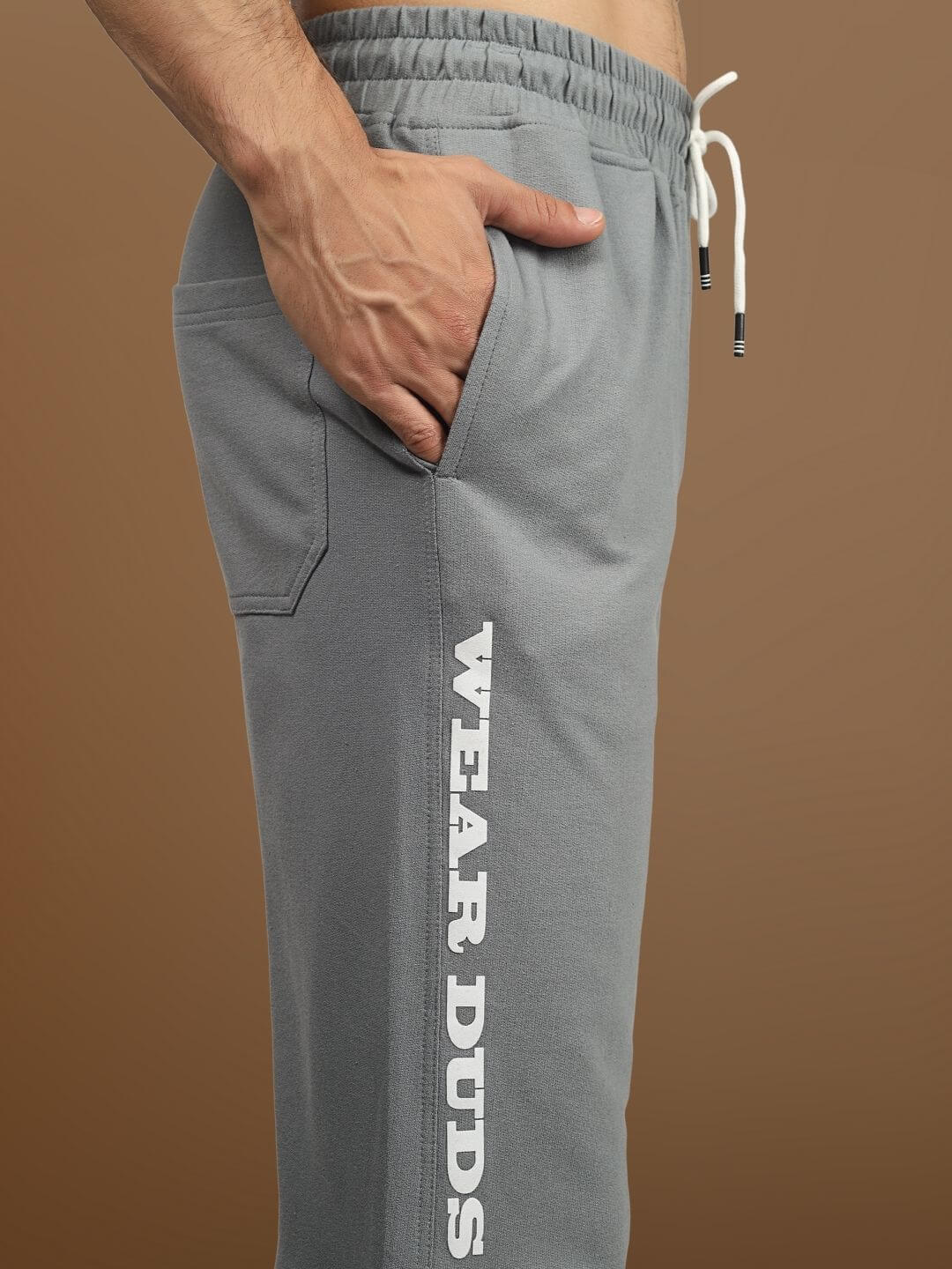 Side view of DUDS Racer Joggers in grey, featuring a comfortable fit and "Wear Duds" branding. Ideal for casual and athletic wear.