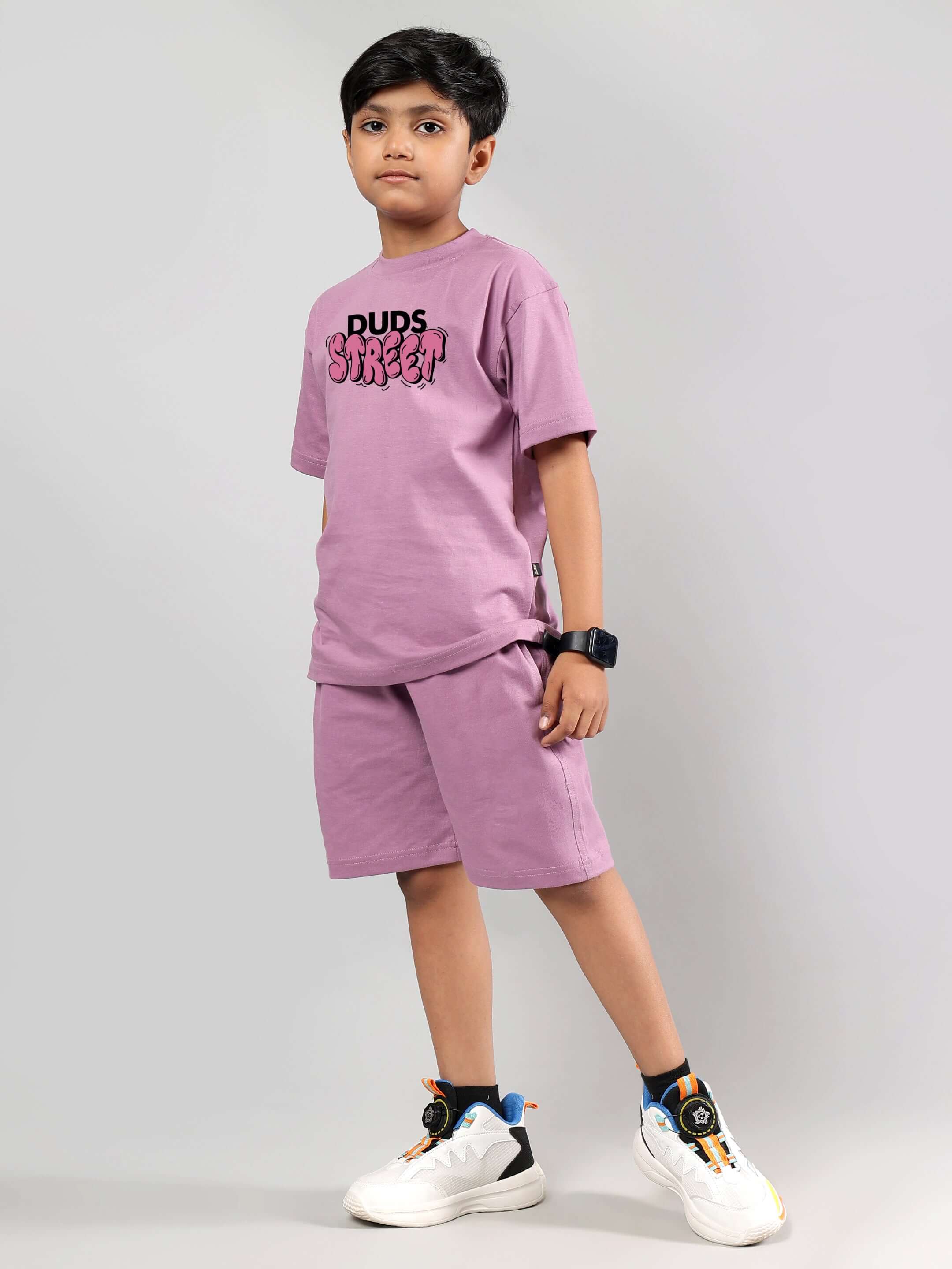 Child wearing DUDS STREET plum purple co-ord set for boys and girls, featuring a T-shirt and shorts, standing confidently.