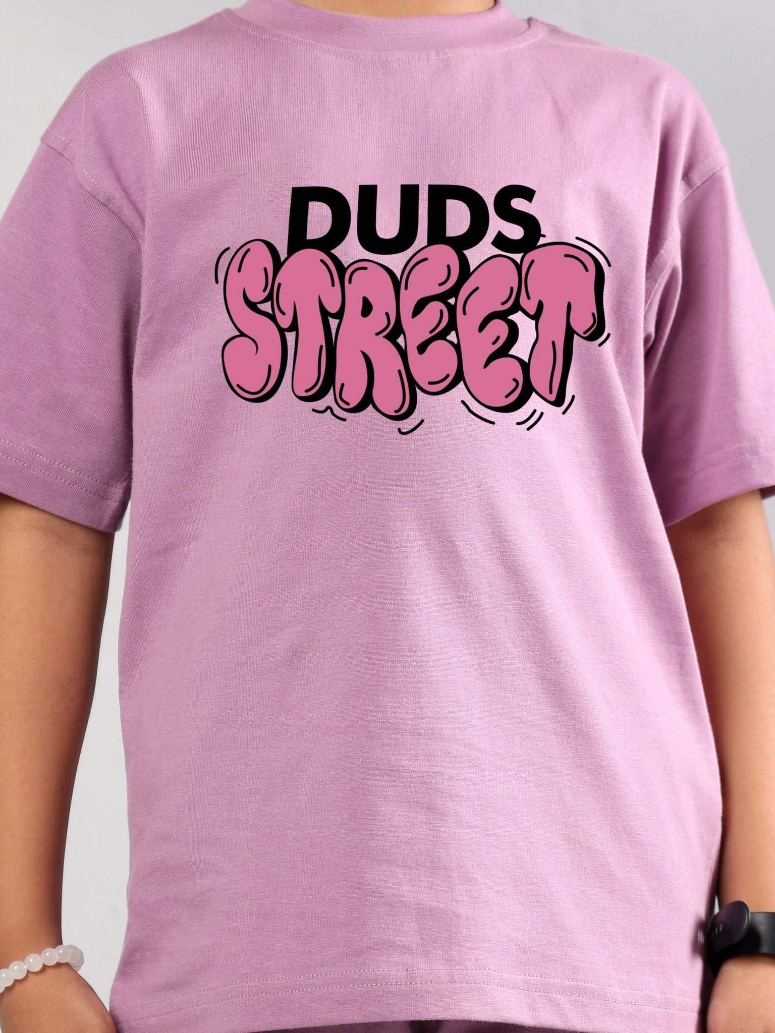 Child wearing DUDS STREET PRINTED T-SHIRT FOR BOYS GIRLS PLUM PURPLE, featuring bold text design, suitable for unisex casual wear.