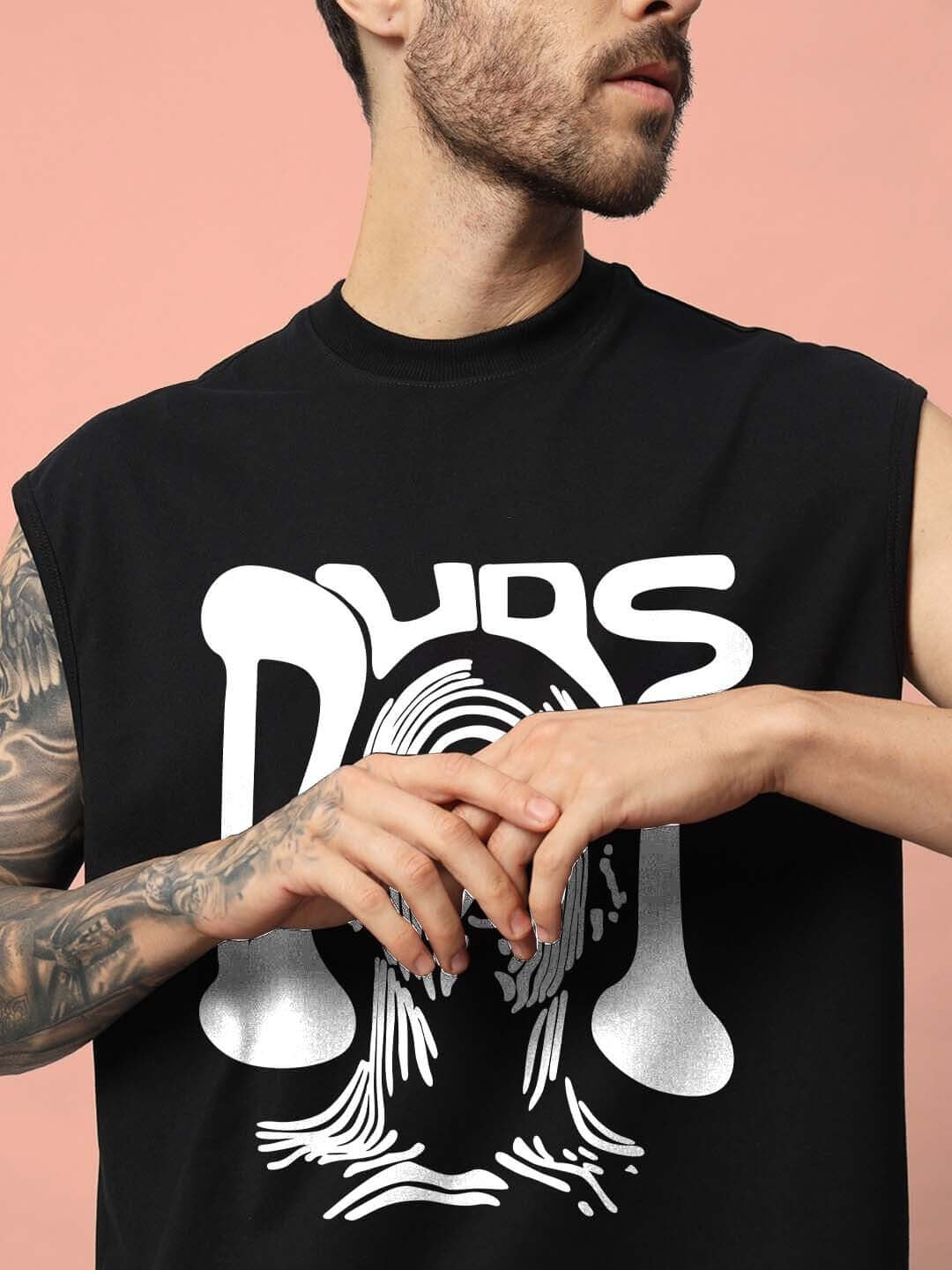 Model wearing black DUDS TASKA gym t-shirt with bold graphic design, displaying athletic style on a peach background.