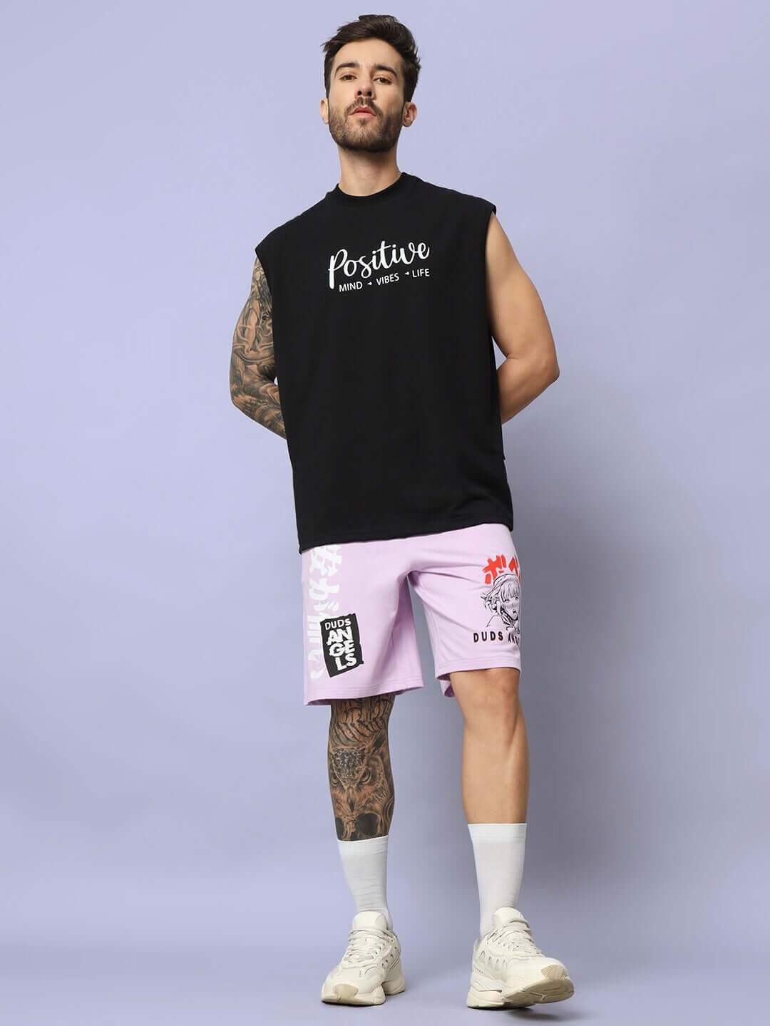 Model wears DUDS Anime Girl Regular Fit Shorts in lilac paired with a black sleeveless top, showcasing casual style.