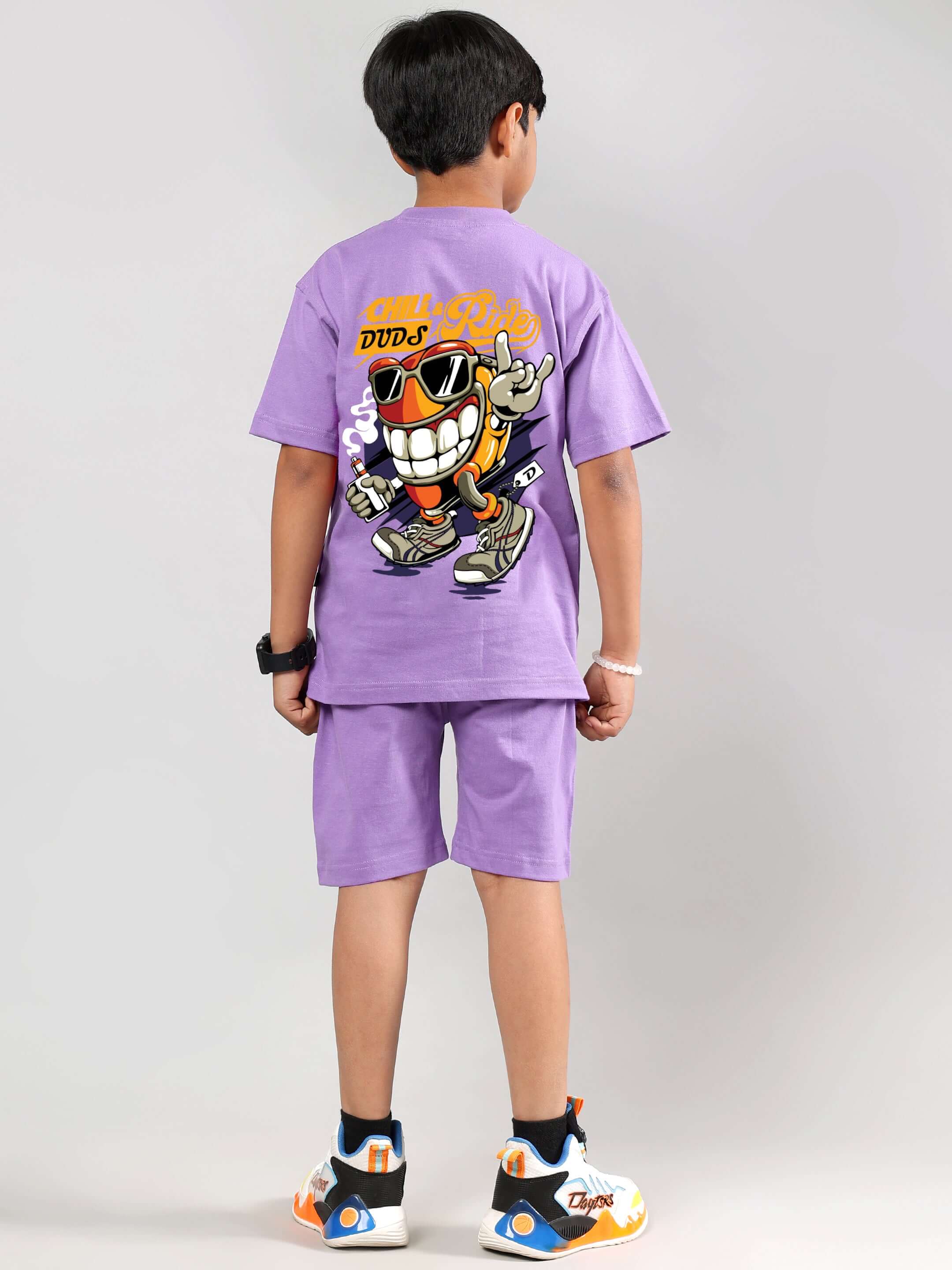 Young boy wearing lavender DUDS Chill & Ride co-ord set, showcasing playful graphic design. Suitable for boys & girls, custom sizes available.