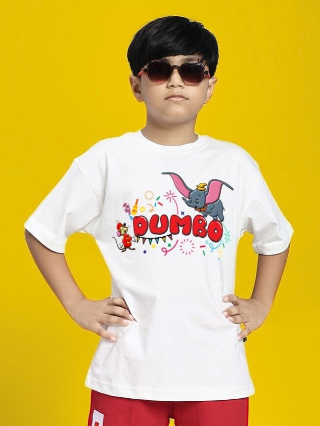 Child wearing DUMBO T-SHIRT FOR BOYS AND GIRLS WHITE standing confidently in front of a yellow background.