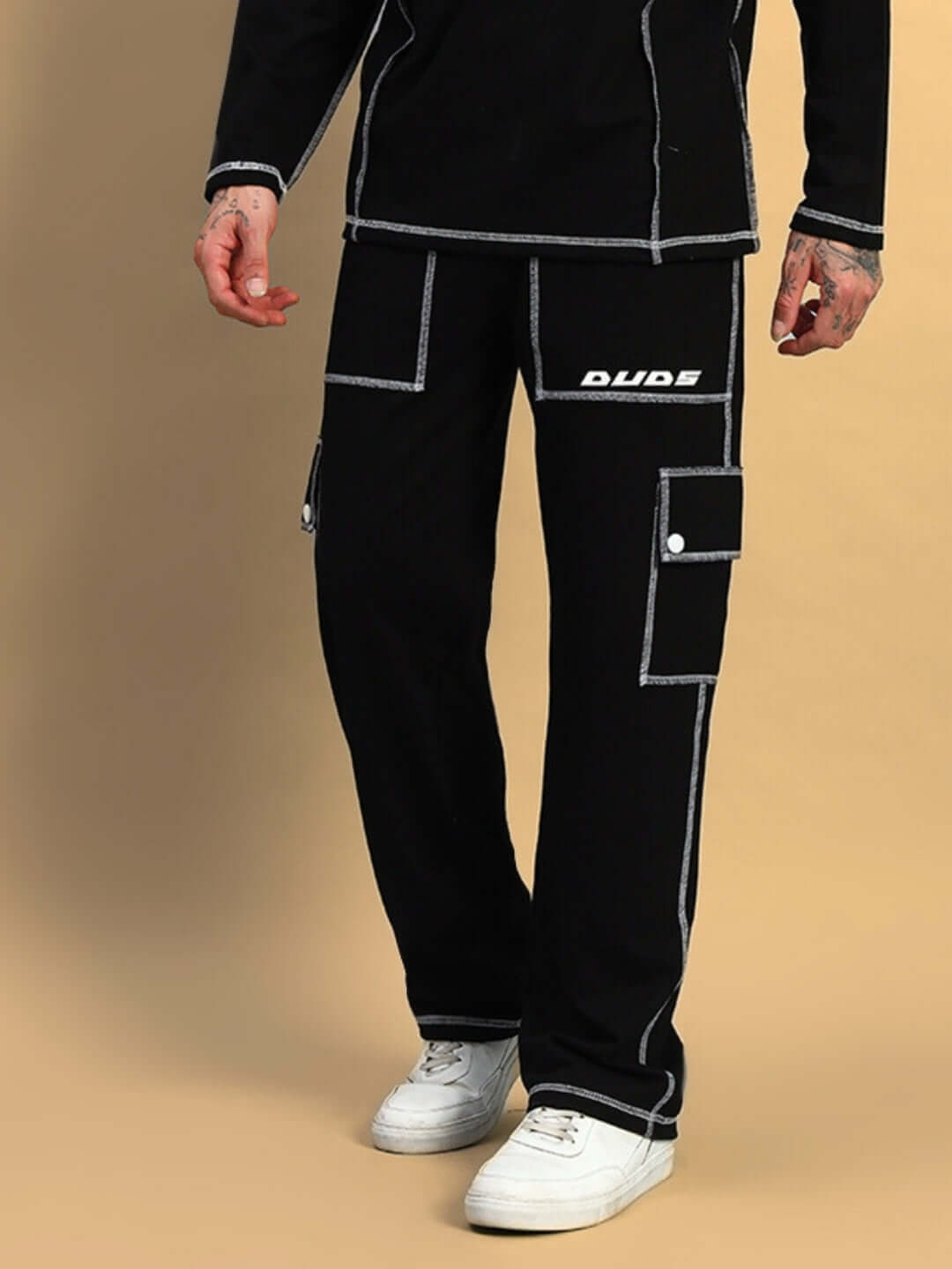 Man wearing black DUDS dynamic 5 pocket cargo pants with white sneakers, highlighting tailor-made construction.