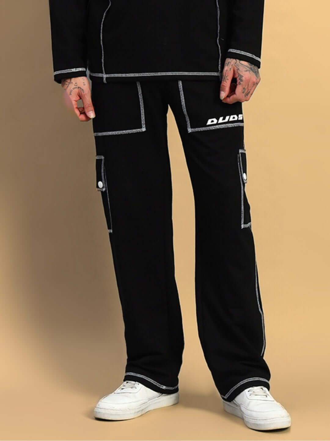 Model wearing black Dynamic 5 Pocket Cargo Pant by DUDS, featuring custom fit option, white sneakers, and contrast stitching.