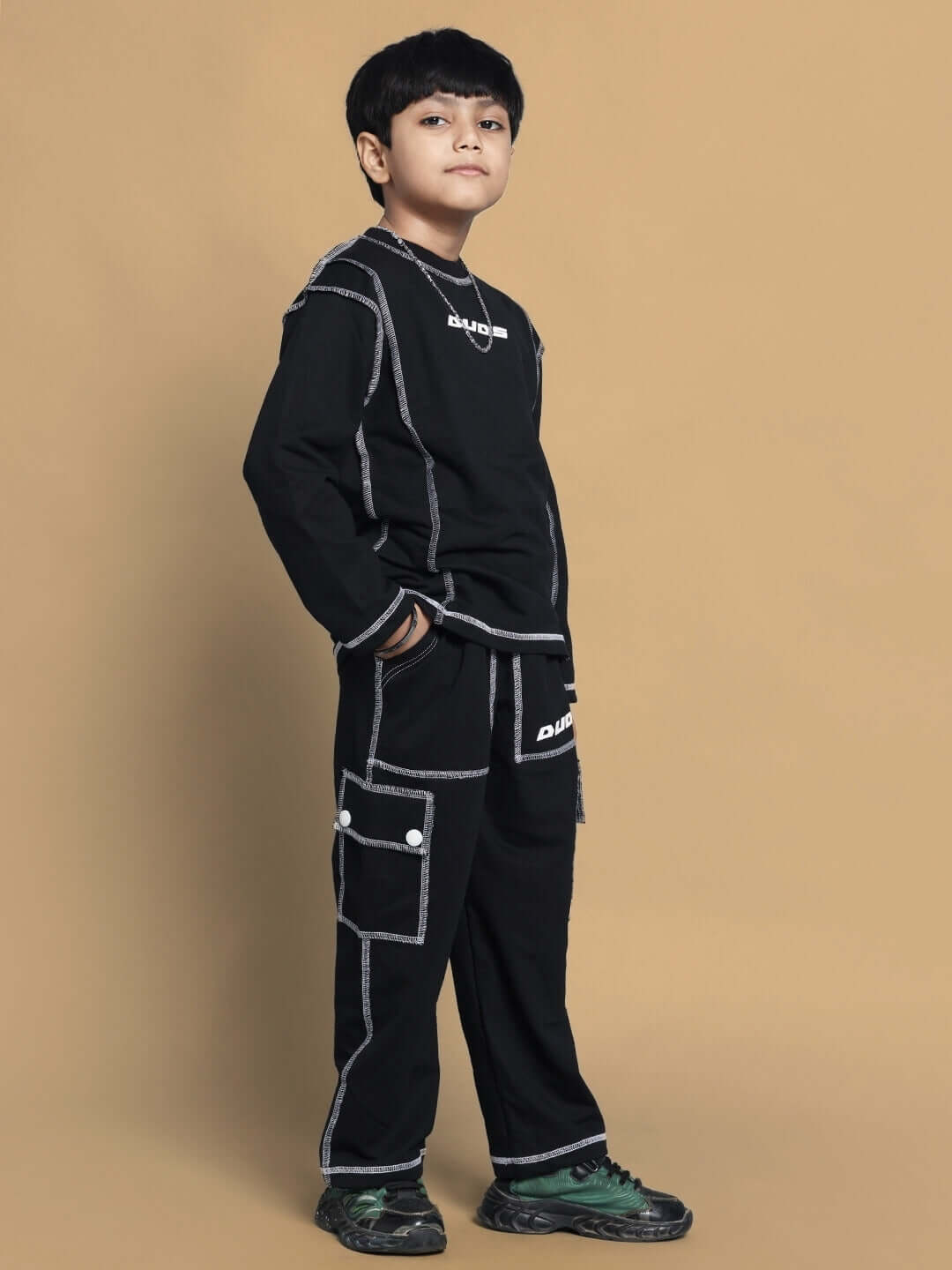 Child modeling Dynamic Oversized Co-Ord Set in black, showcasing unisex relaxed fit joggers with drawstring and elasticated waistband.