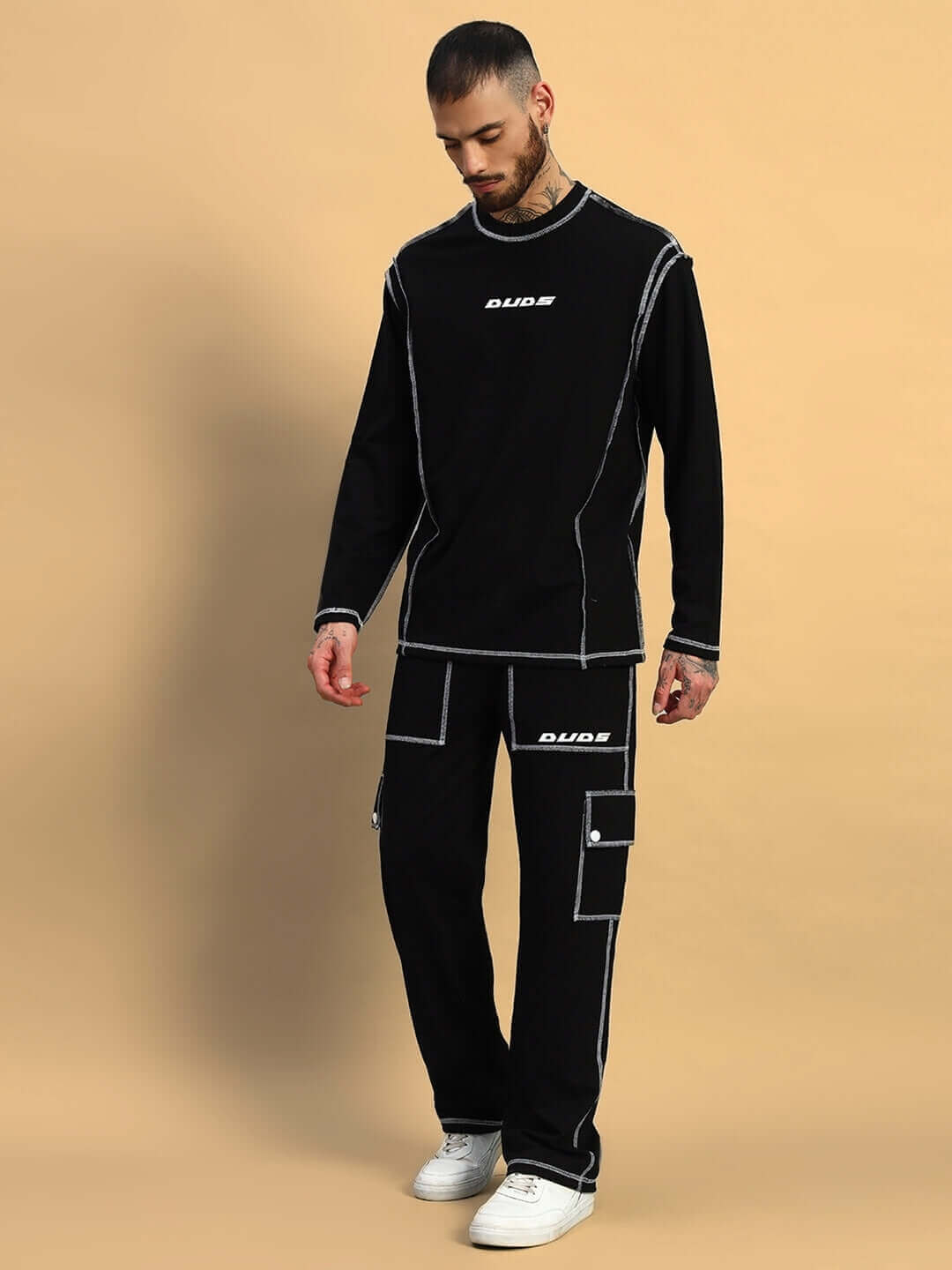 Model wearing black dynamic 5 pocket cargo pant with tailored fit from DUDS, styled with a matching top, showcasing modern streetwear fashion.