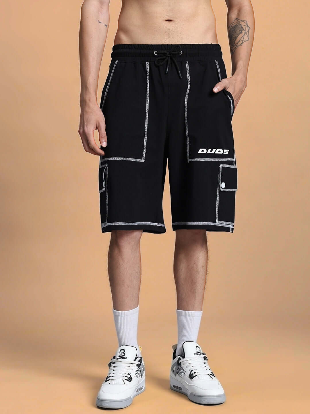 Man wearing DYNAMIC REGULAR FIT SHORTS BLACK with sporty design, showcasing unisex style and comfort.