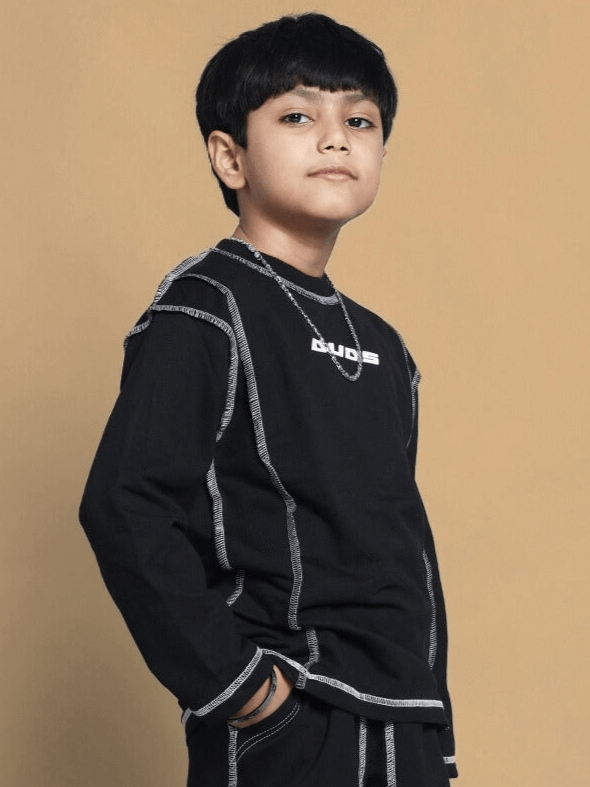 Young boy wearing dynamic oversized black sweatshirt with premium cotton blend, suitable for both boys and girls, against a neutral background.