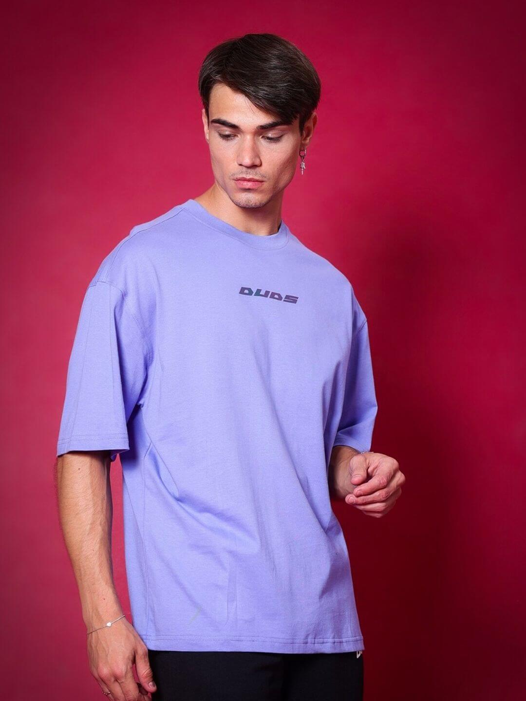Model wearing BREATHE OVER-SIZED T-SHIRT PERIWINKLE against a red background