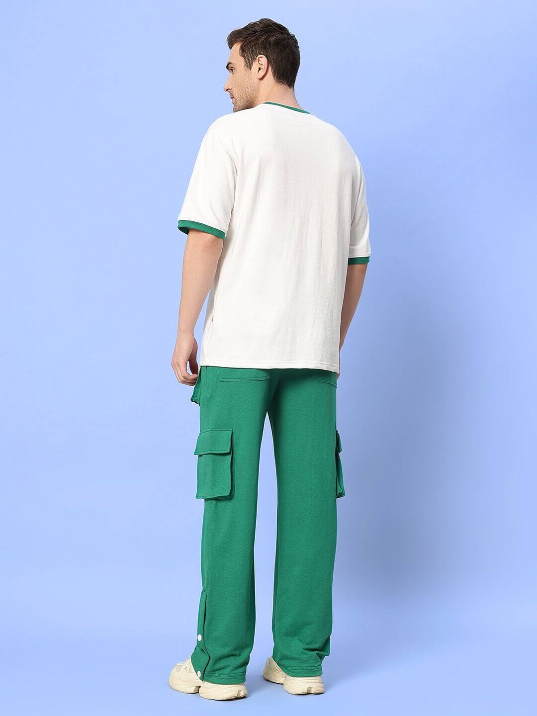 Back view of a model wearing the EASTON COTTON CO-ORD SET GREEN-WHITE, featuring white top and green pants with side pockets.