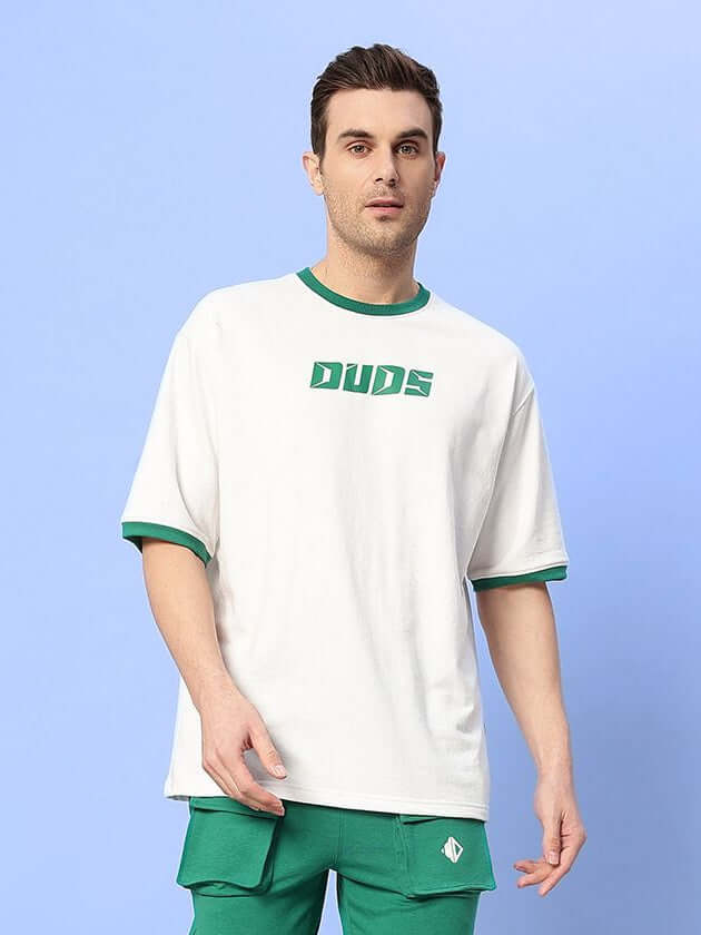 Model wearing EASTON BOXY FIT T-SHIRT WHITE-GREEN with green trim and logo, showing casual and relaxed style.