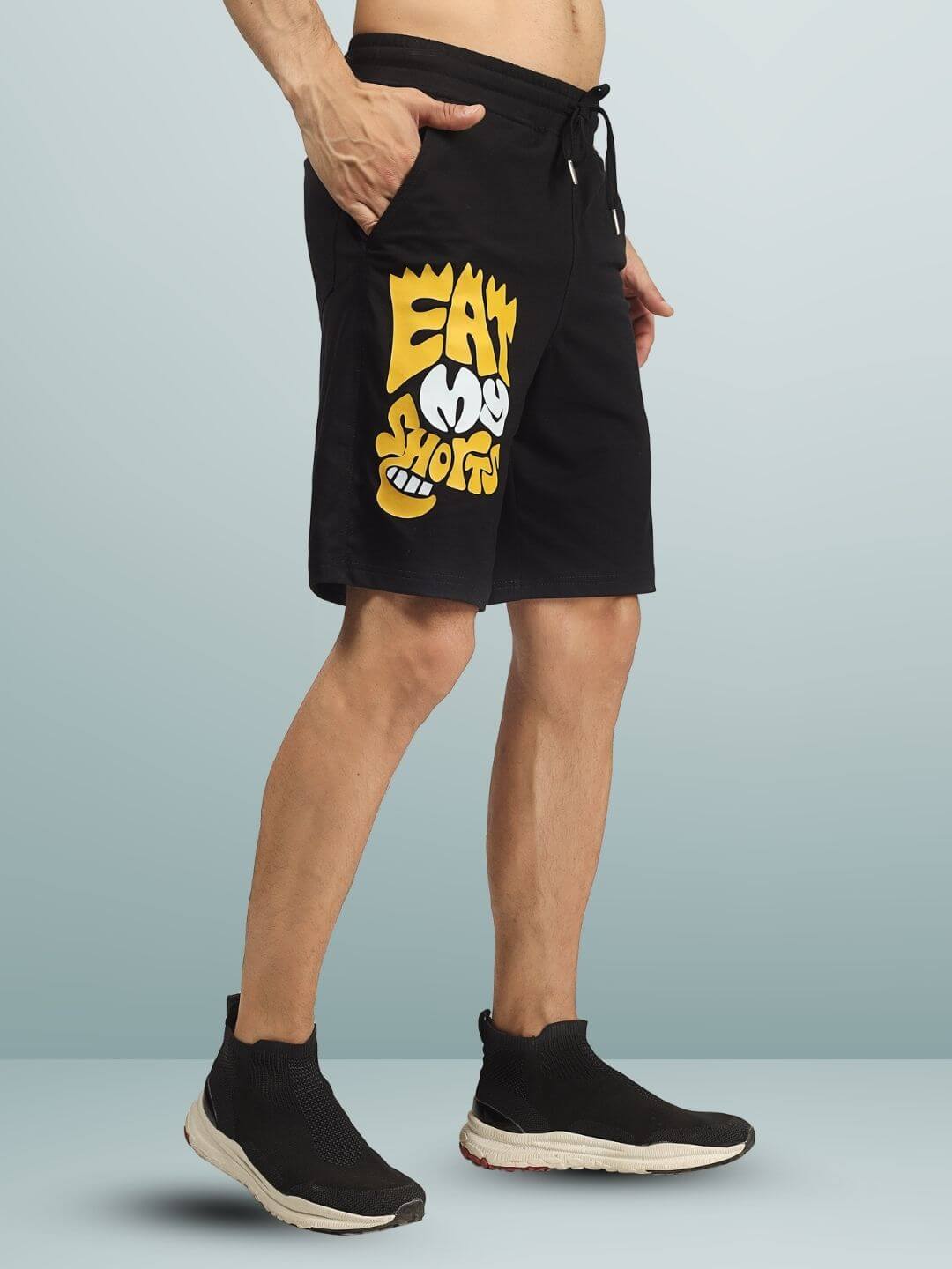 EAT MY SHORTS regular fit black shorts featuring bold yellow graphic design on side, perfect for casual wear.