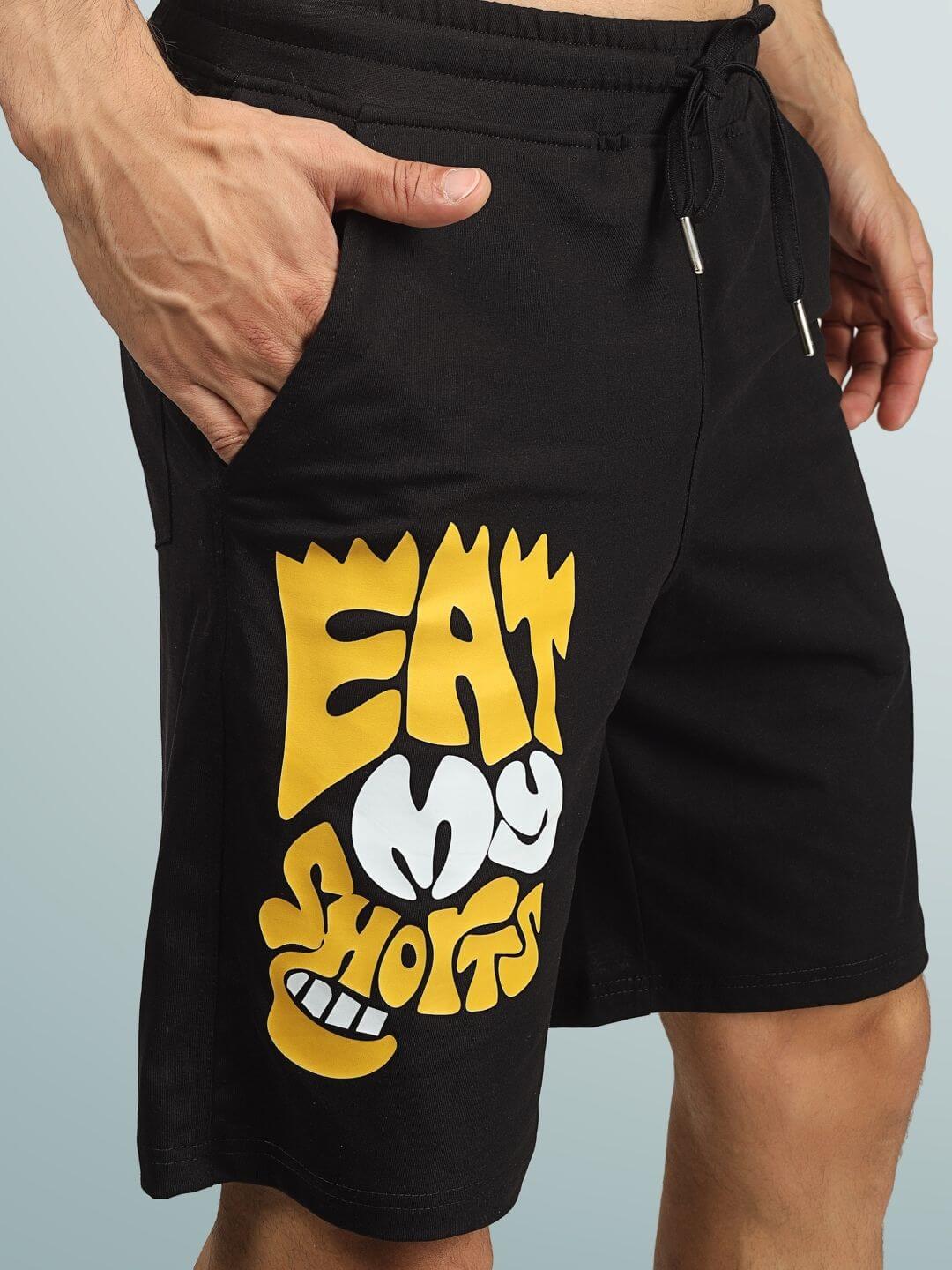 Black regular fit shorts featuring bold yellow 'Eat My Shorts' graphic, customizable sizing option available for handmade, dedicated craftsmanship.