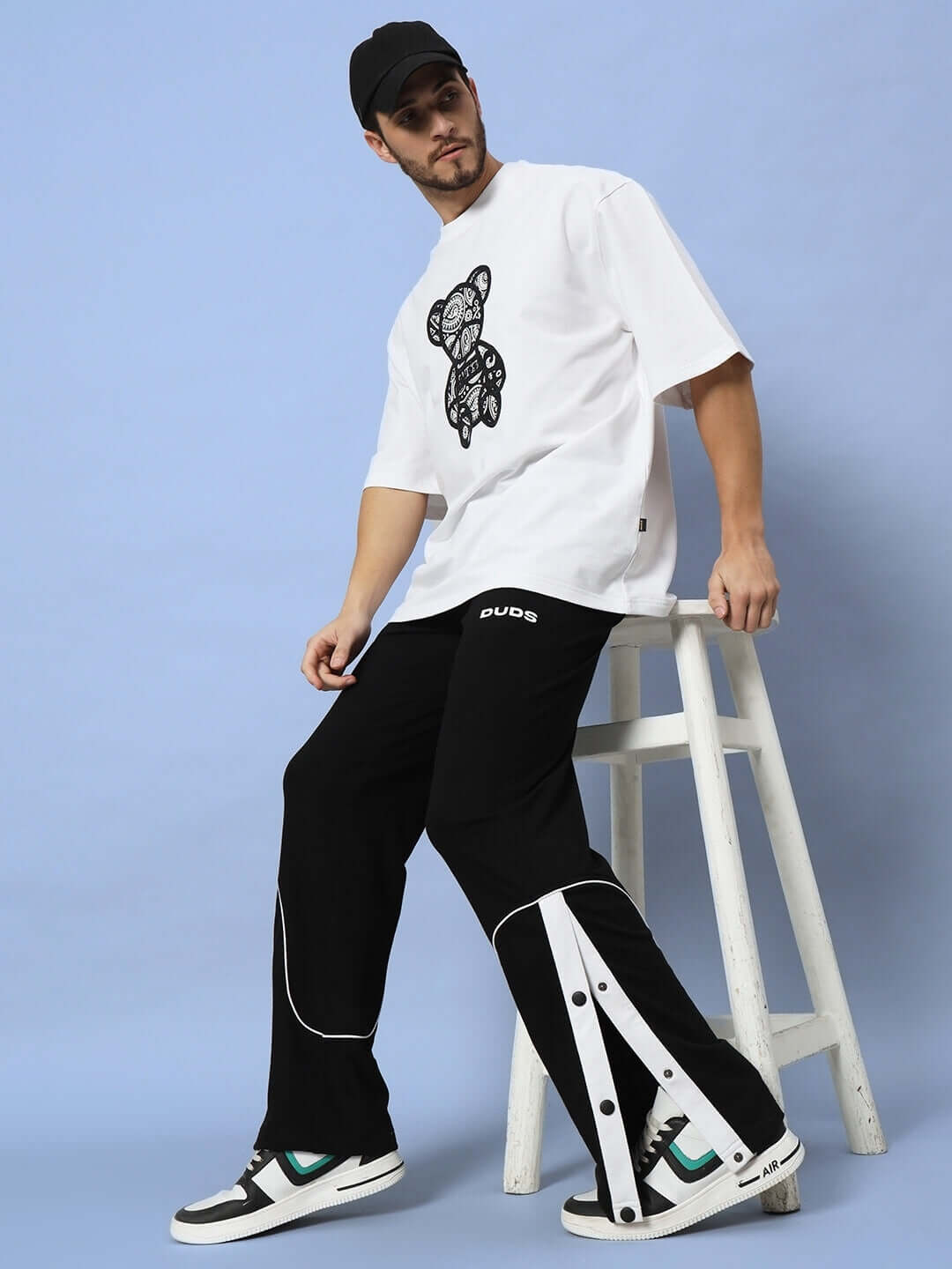 Model wearing EDDIE CONTRAST JOGGERS in black with white detailing, styled with casual tee and sneakers, showcasing DUDS fashion.