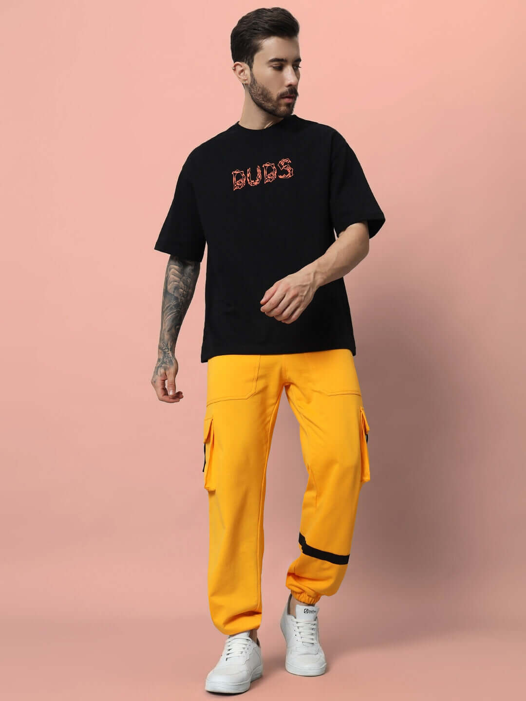Man wearing EDIFICE RELAXED FIT CARGO PANT YELLOW, showing vibrant yellow color and relaxed fit, styled with black t-shirt and white sneakers.
