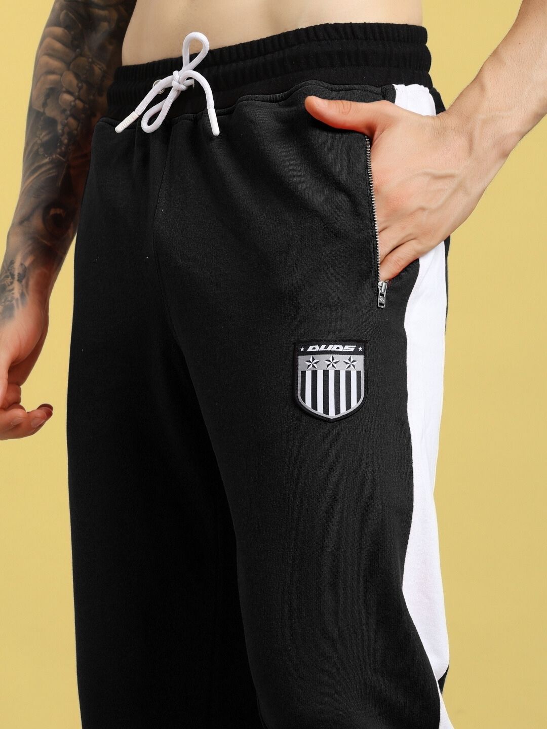 Close-up of ELEGANT RELAXED-FIT JOGGERS BLACK with logo detail, showcasing premium style and comfort for modern minimalism.