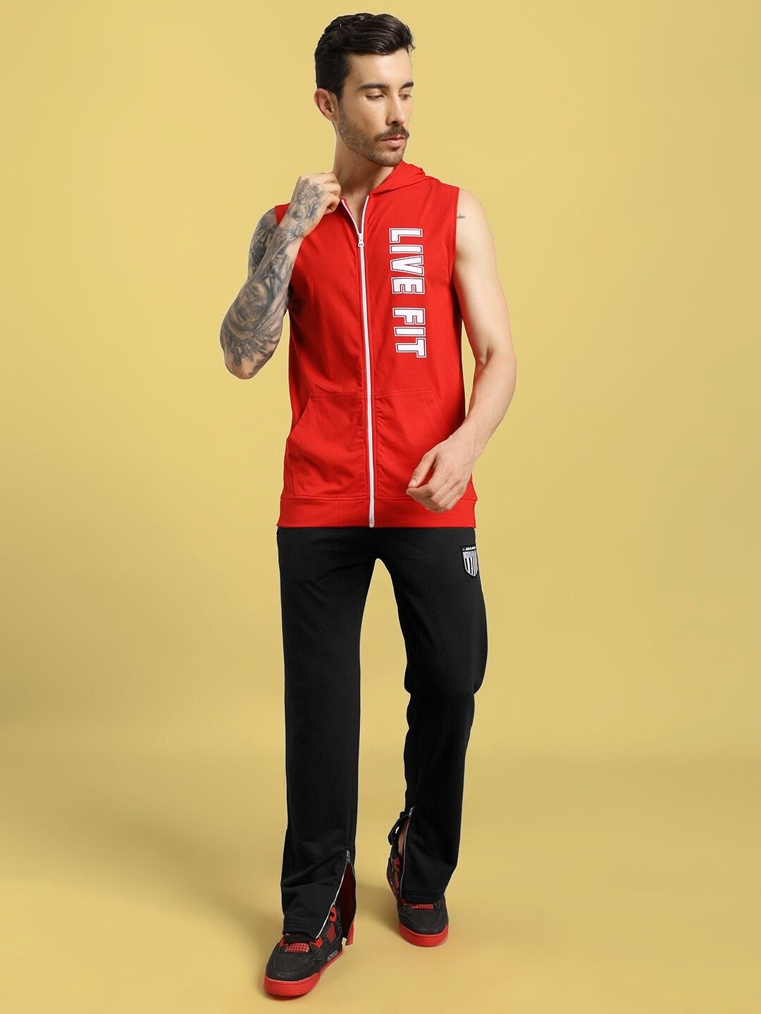 Man wearing Elegant Relaxed-Fit Joggers Black with red sleeveless top, showcasing casual style and comfort.