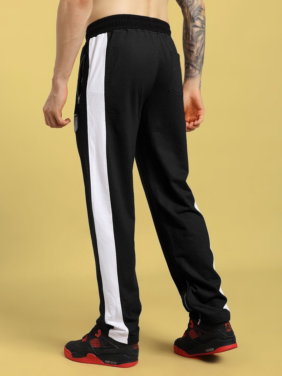 Back view of a person wearing ELEGANT RELAXED-FIT JOGGERS BLACK with white stripe detail, showcasing comfortable and stylish fit.