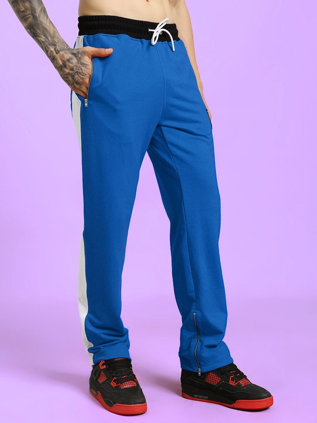 Man wearing ELEGANT RELAXED-FIT JOGGERS BLUE on purple background.