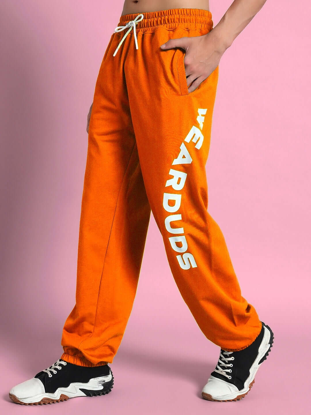 Model wearing orange Ellen relaxed fit jogger with 'WEAR DUDS' text, highlighting custom fit option for tailored comfort.