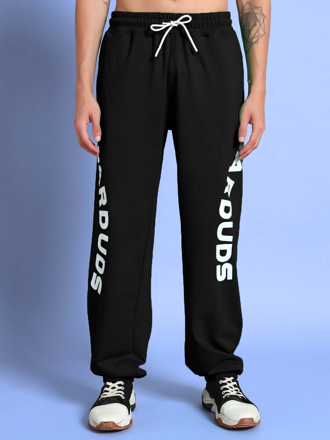 Model wearing Ellen Relaxed Fit Jogger in black by DUDS, featuring adjustable drawstring and logo detail on leg.