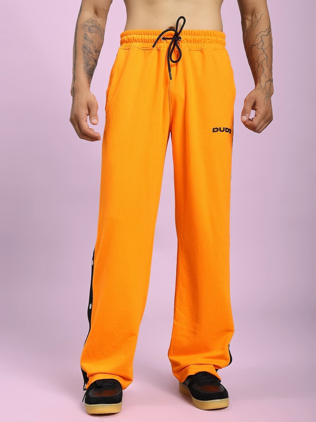 EMBER BOLT SIDE JOGGER IN ORANGE with sleek side stripe and vibrant hue, showcasing comfort and style in a casual wear setting.
