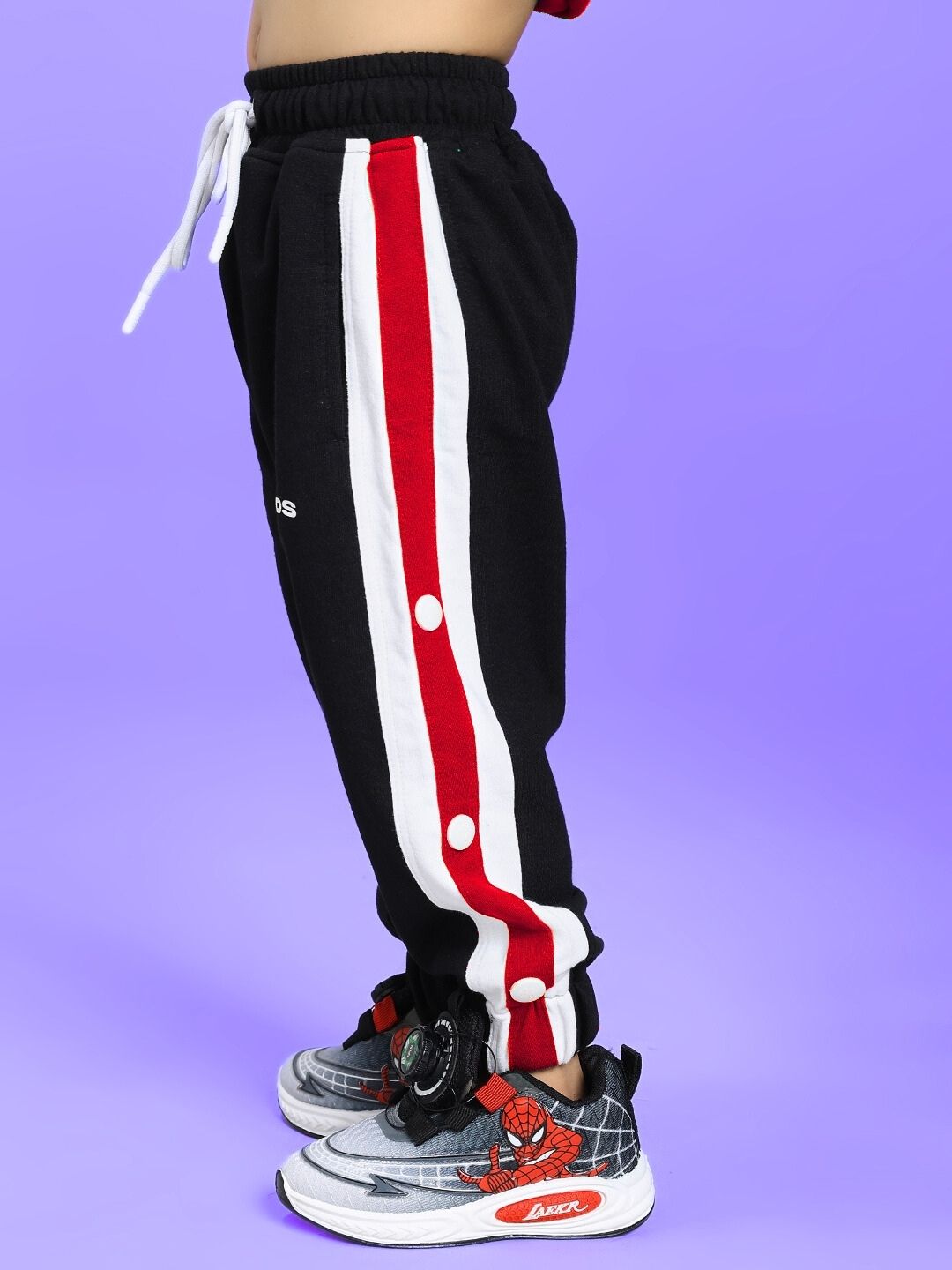 EMIRATI JOGGER FOR BOYS AND GIRLS BLACK BLACK RED with red and white stripe detail, side view on child model.