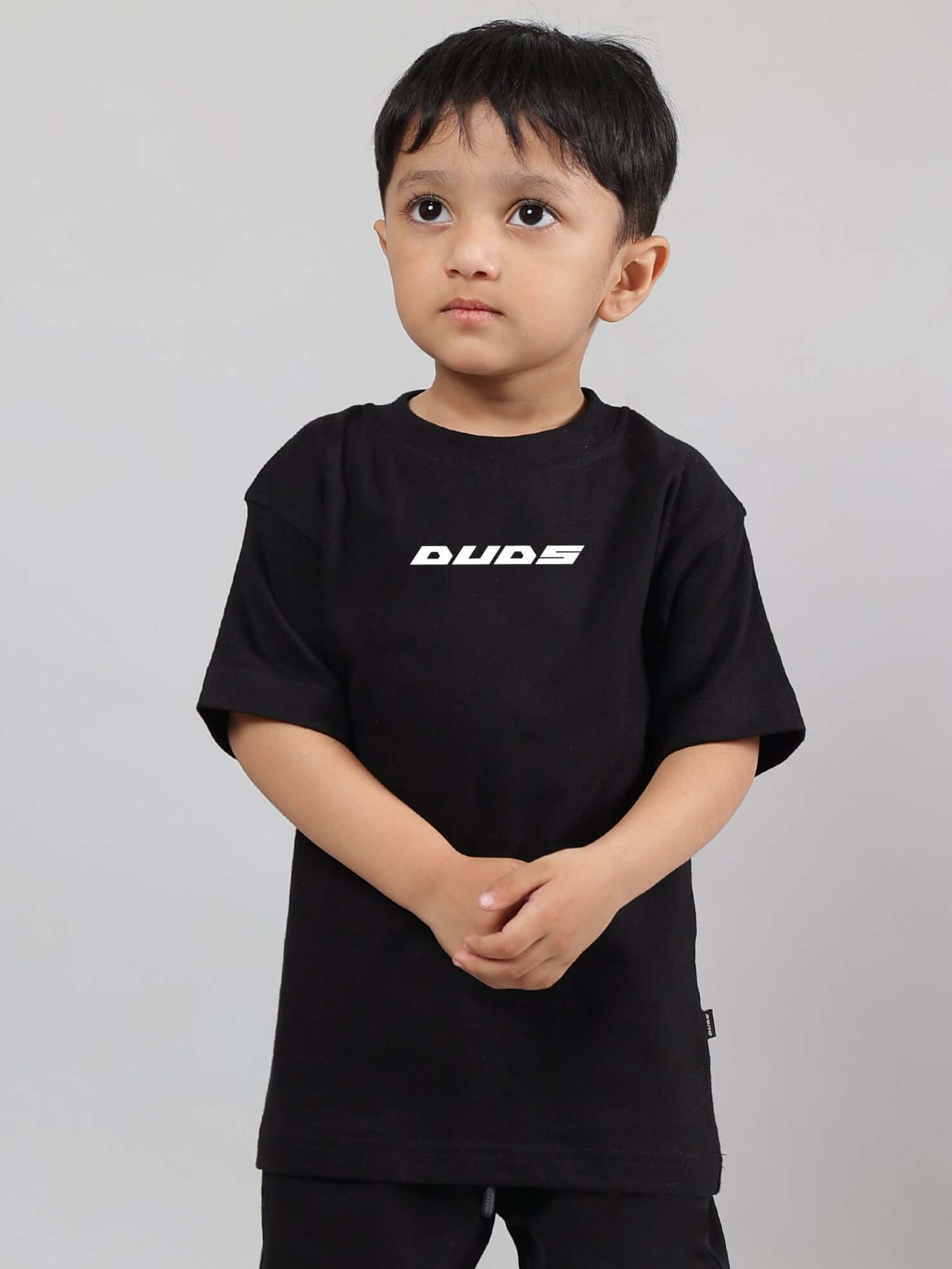 Alt Tag: Child wearing a black 'Enjoy the Wind' t-shirt by DUDS, made for boys and girls, customized fit option available.