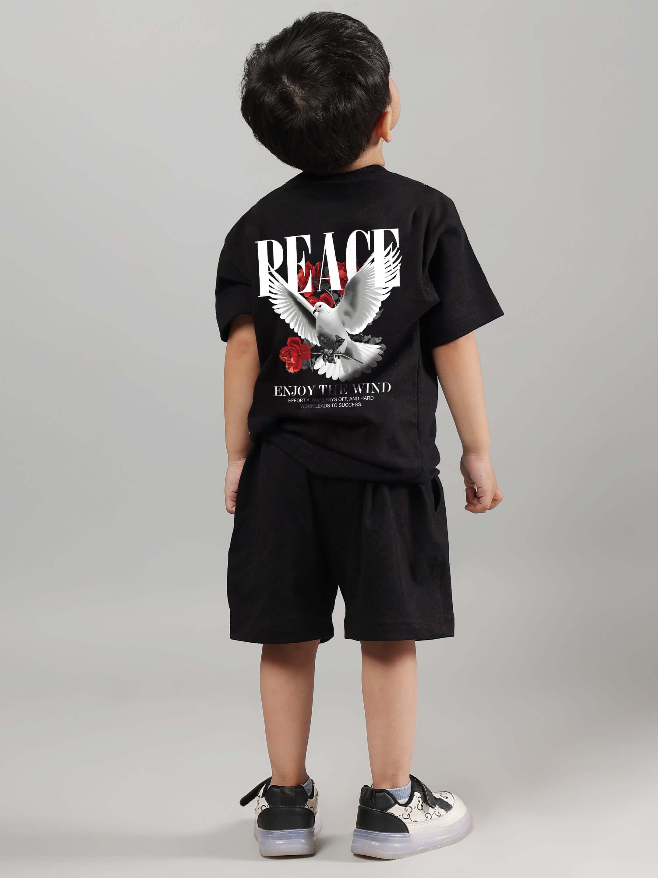 Child wearing black 'Enjoy the Wind' co-ord set featuring peace dove design. Unisex outfit for boys and girls by DUDS.