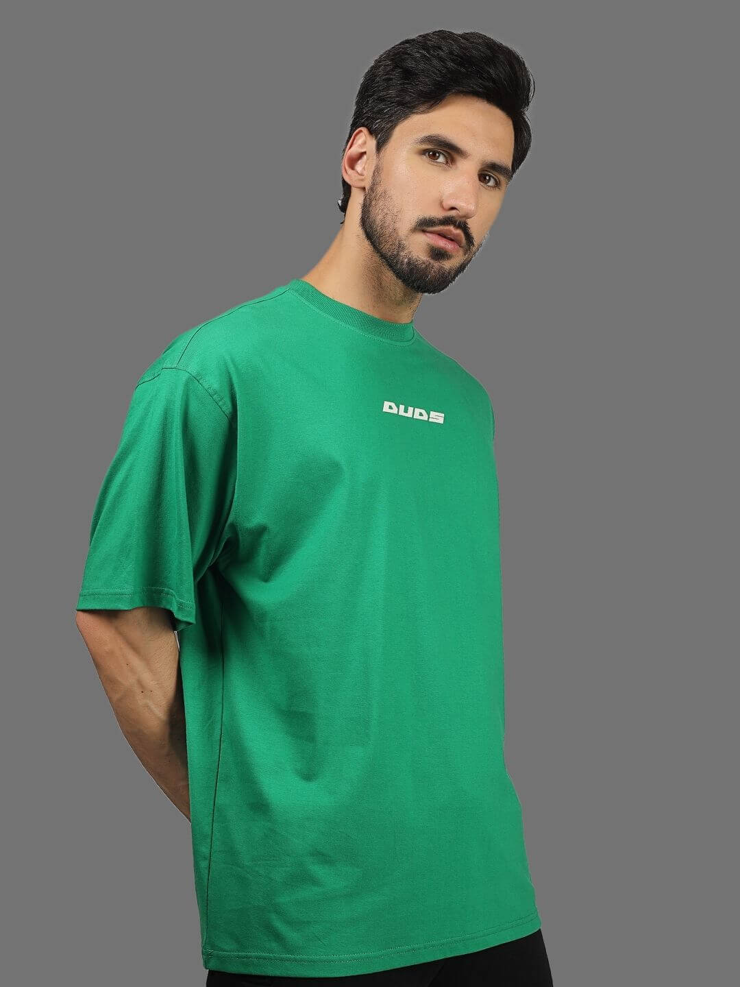 Model wearing DUDS ETCETERA oversized green t-shirt, showcasing comfortable fit. Custom fit option available for prepaid orders.