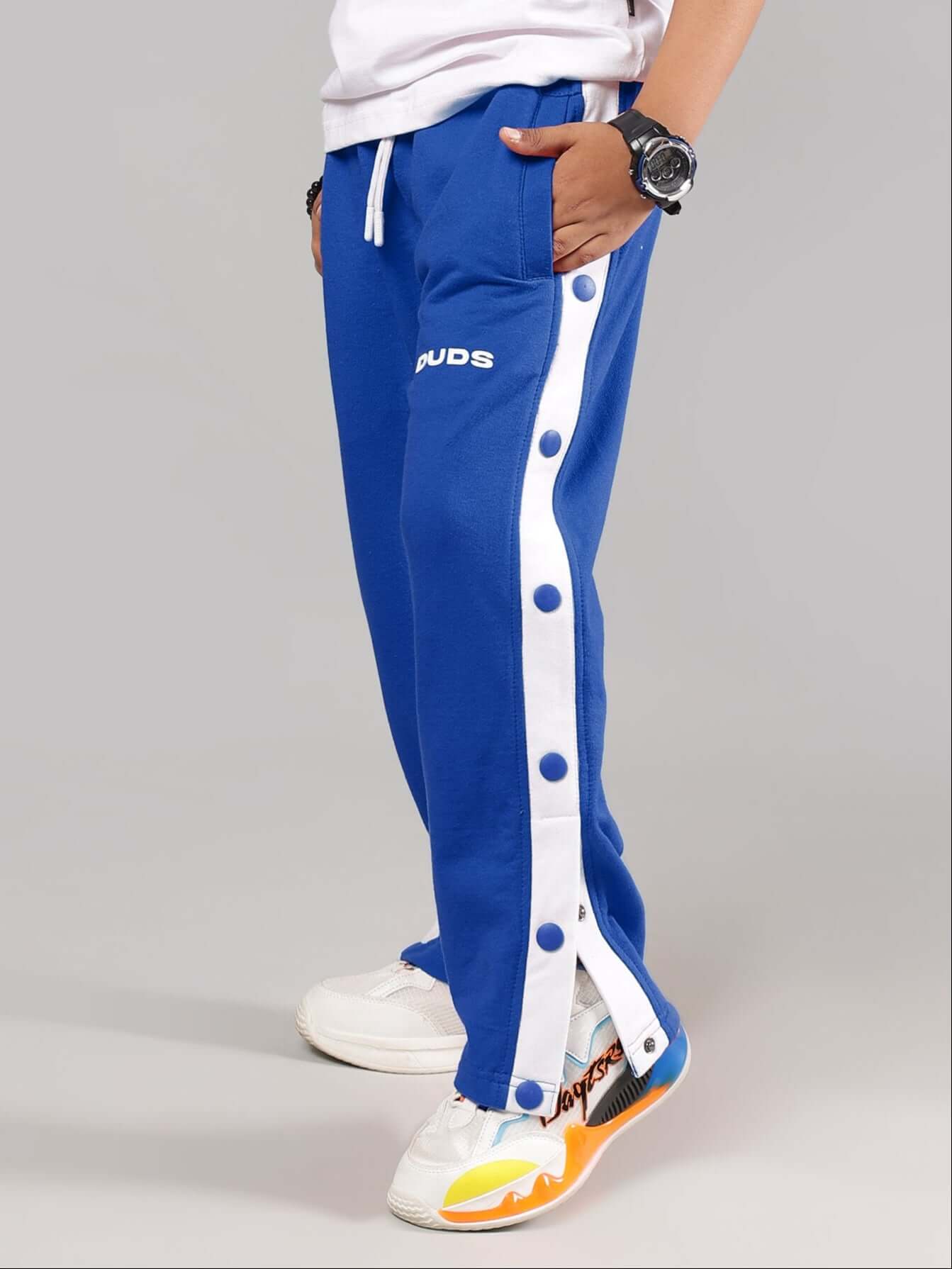Boy wearing EZEL JOGGER FOR BOYS & GIRLS BLUE with side buttons and pockets, showcasing comfortable fit and style.