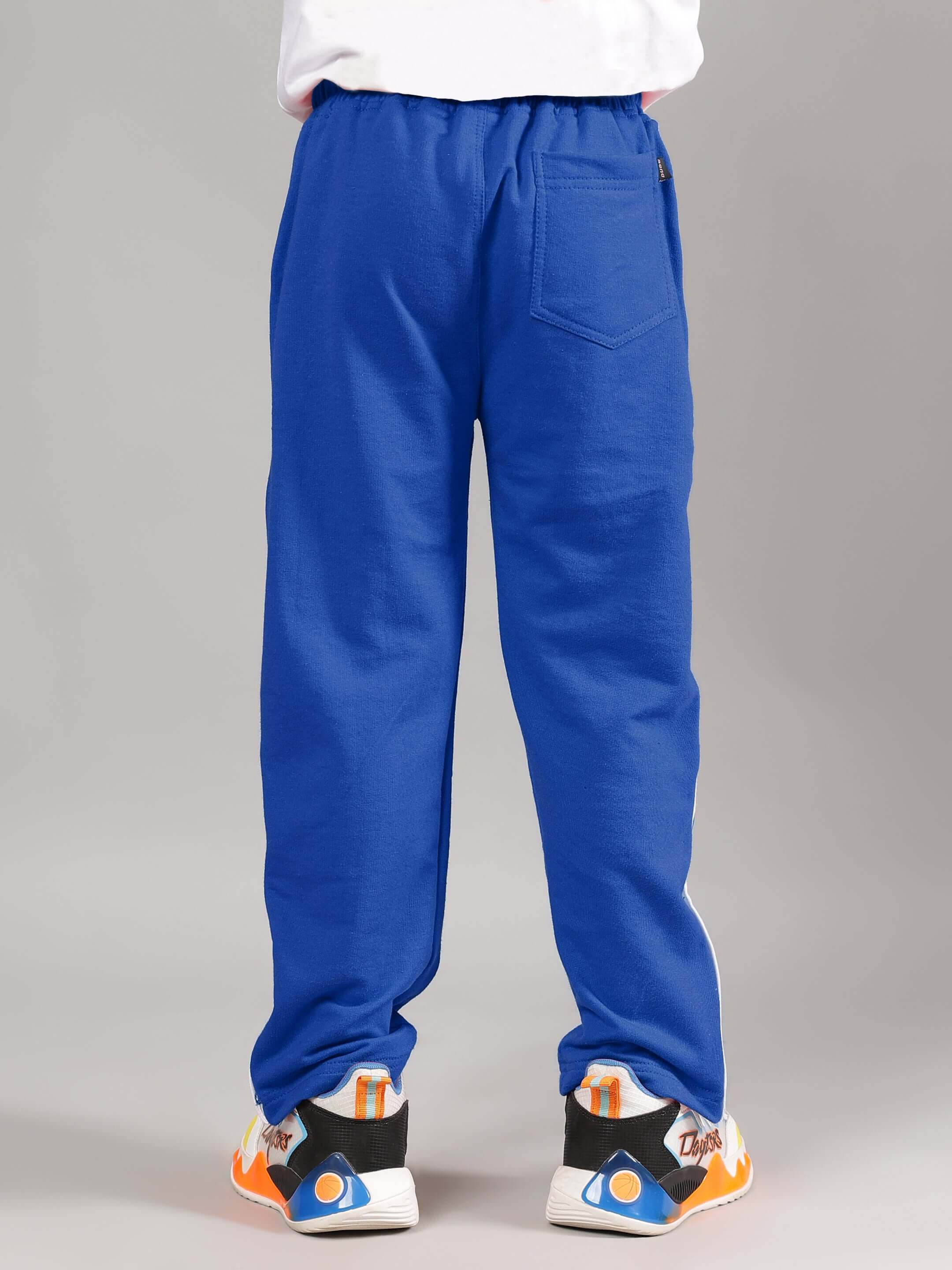 EZEL JOGGER FOR BOYS & GIRLS BLUE - back view of blue jogger pant with elastic waistband and back pocket, worn with sneakers.