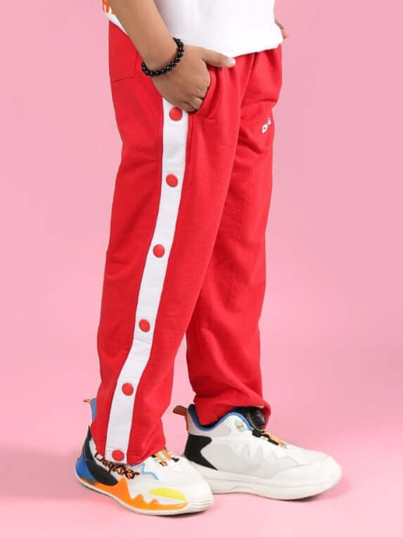 Child wearing red EZEL jogger pants with button detailing, designed for boys and girls. Tailored by DUDS, available for custom fit.