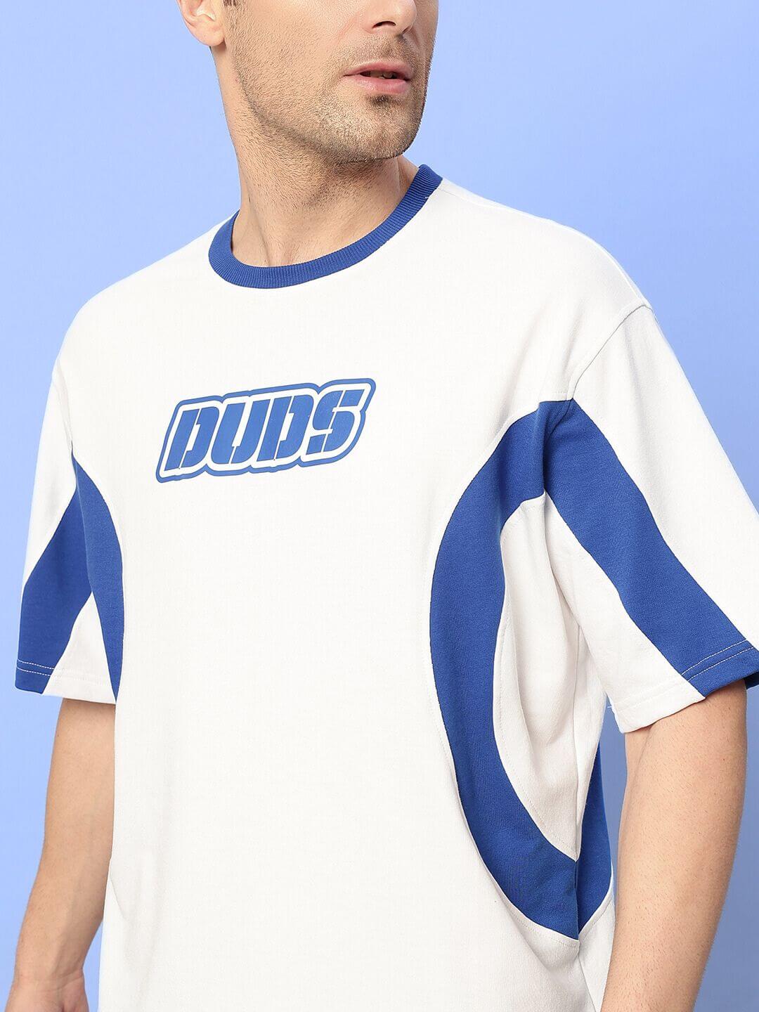 Man wearing EZEL OVER-SIZED T-SHIRT WHITE-BLUE, made from premium cotton, featuring bold blue accents for a trendy streetwear look.