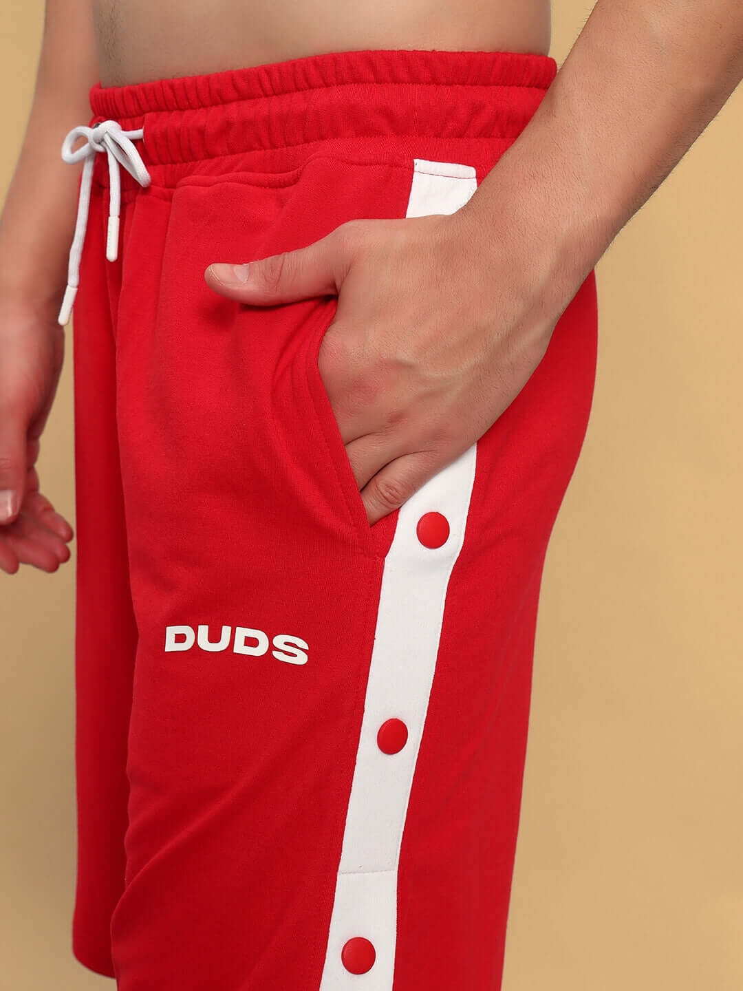 Side view of EZEL REGULAR FIT COTTON SHORTS RED showing pocket detail, featuring white buttons and "Duds" text.