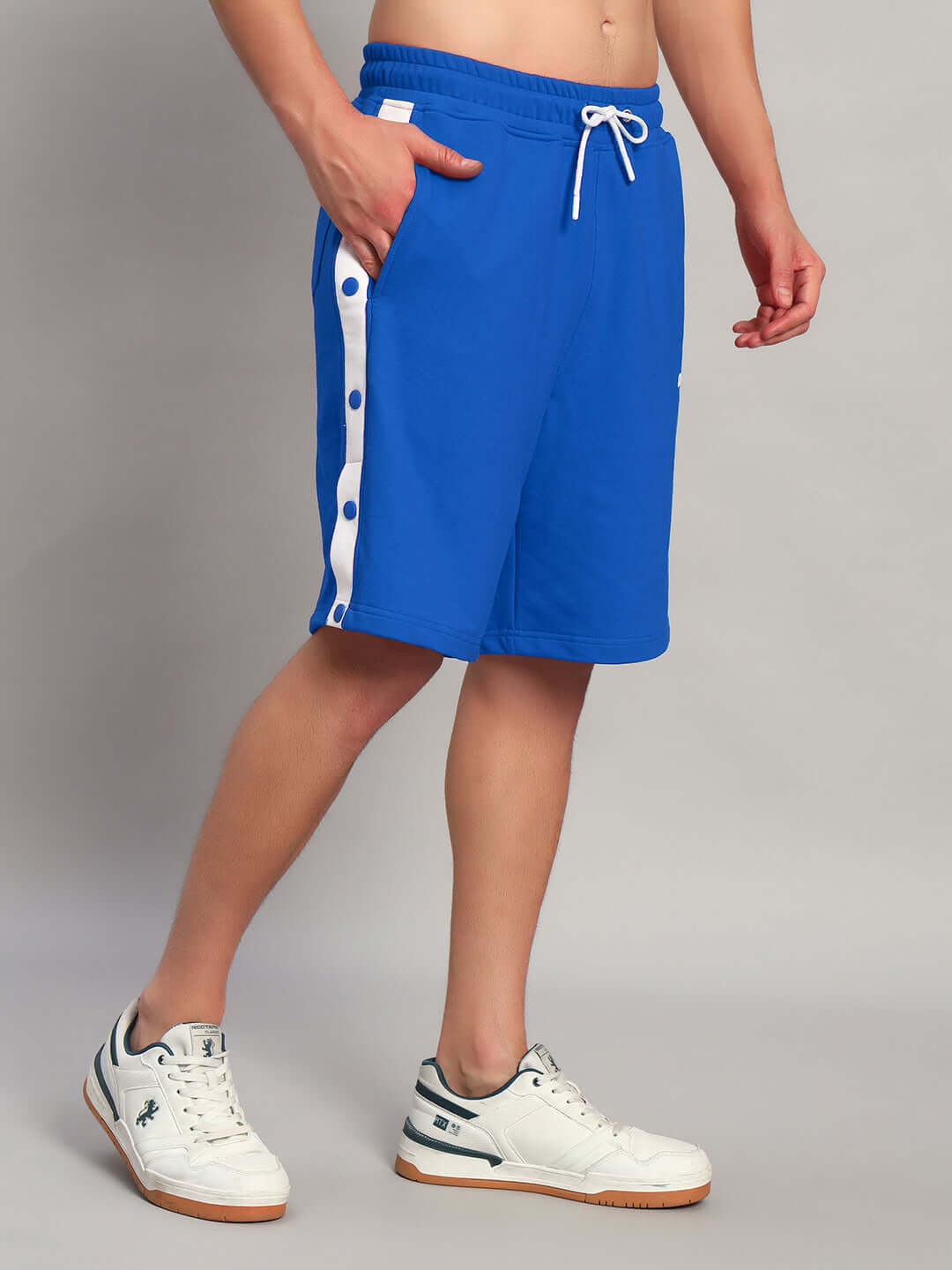 Man wearing EZEL REGULAR FIT COTTON SHORTS BLUE showcasing side button design and drawstring waist.