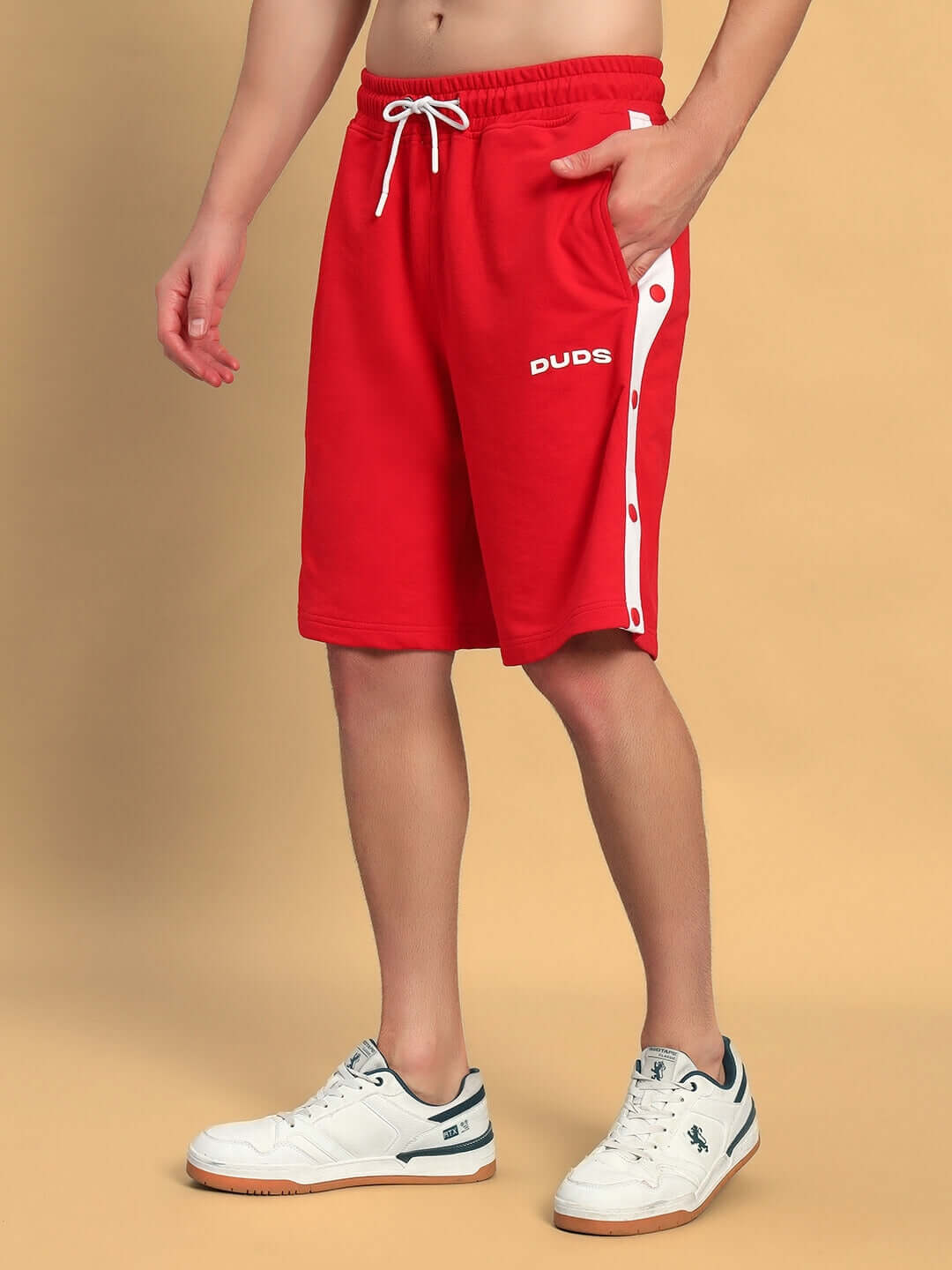 Person wearing EZEL REGULAR FIT COTTON SHORTS RED with white sneakers, showcasing casual style.