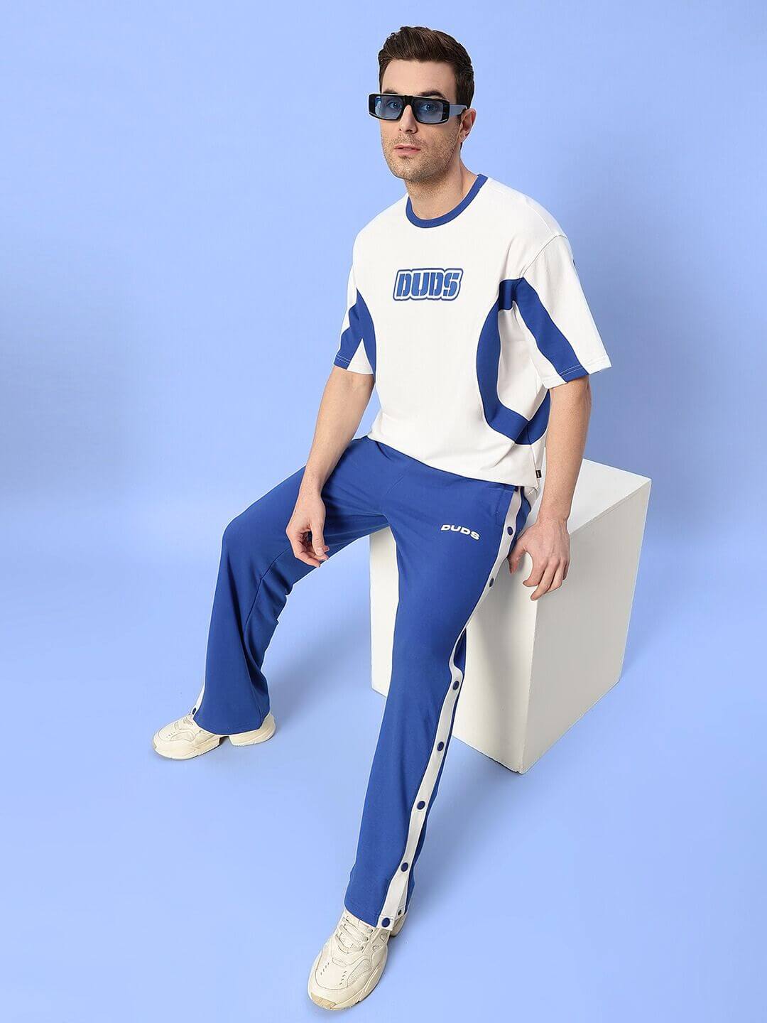 Man wearing EZEL RELAXED FIT CO-ORD SET WHITE-BLUE sitting on white cube