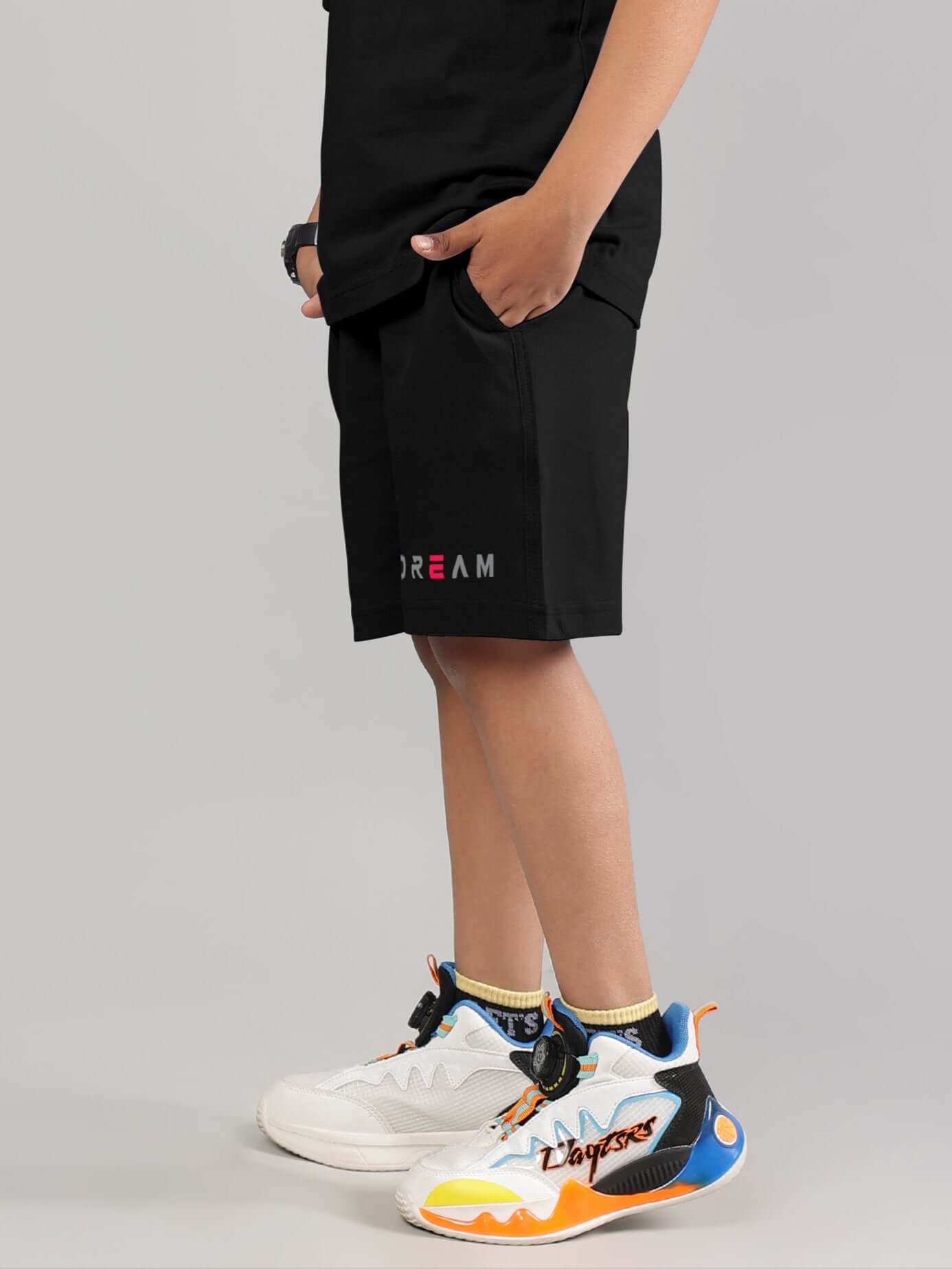 Child wearing Fancy Dream Black Shorts with colorful sneakers, perfect for boys and girls, customizable for a perfect fit.