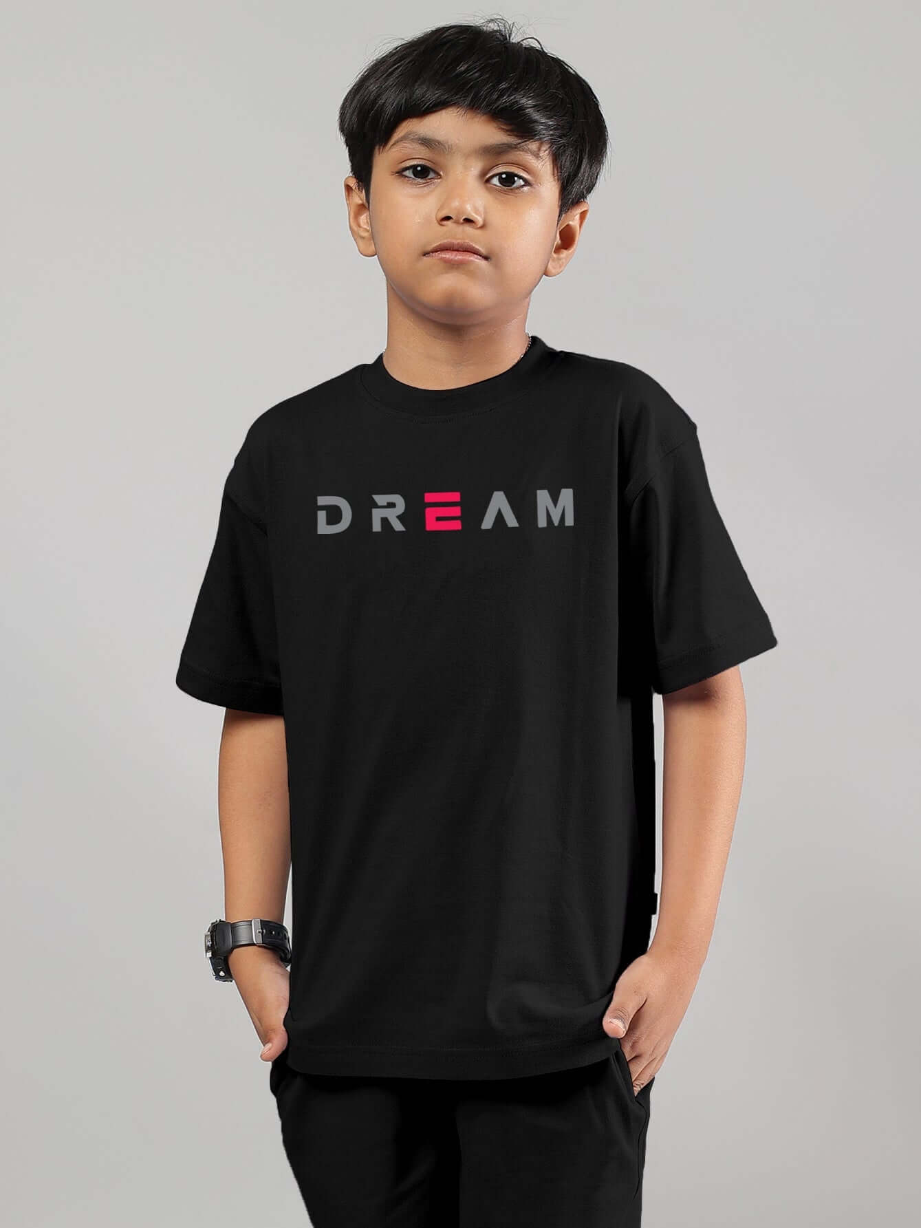 Child wearing a black Fancy Dream T-shirt by DUDS, suitable for boys and girls, showcasing casual style and customizable fit.