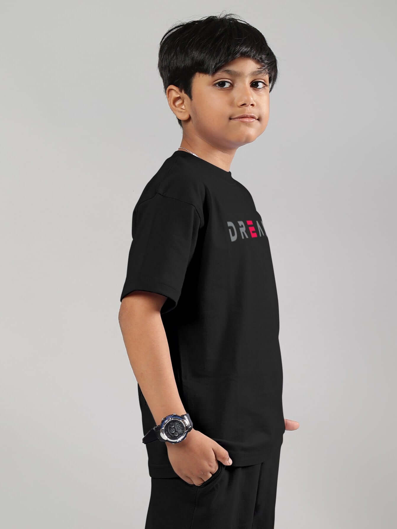Child wearing Fancy Dream black T-shirt for boys & girls, side profile view, available with custom fit option.