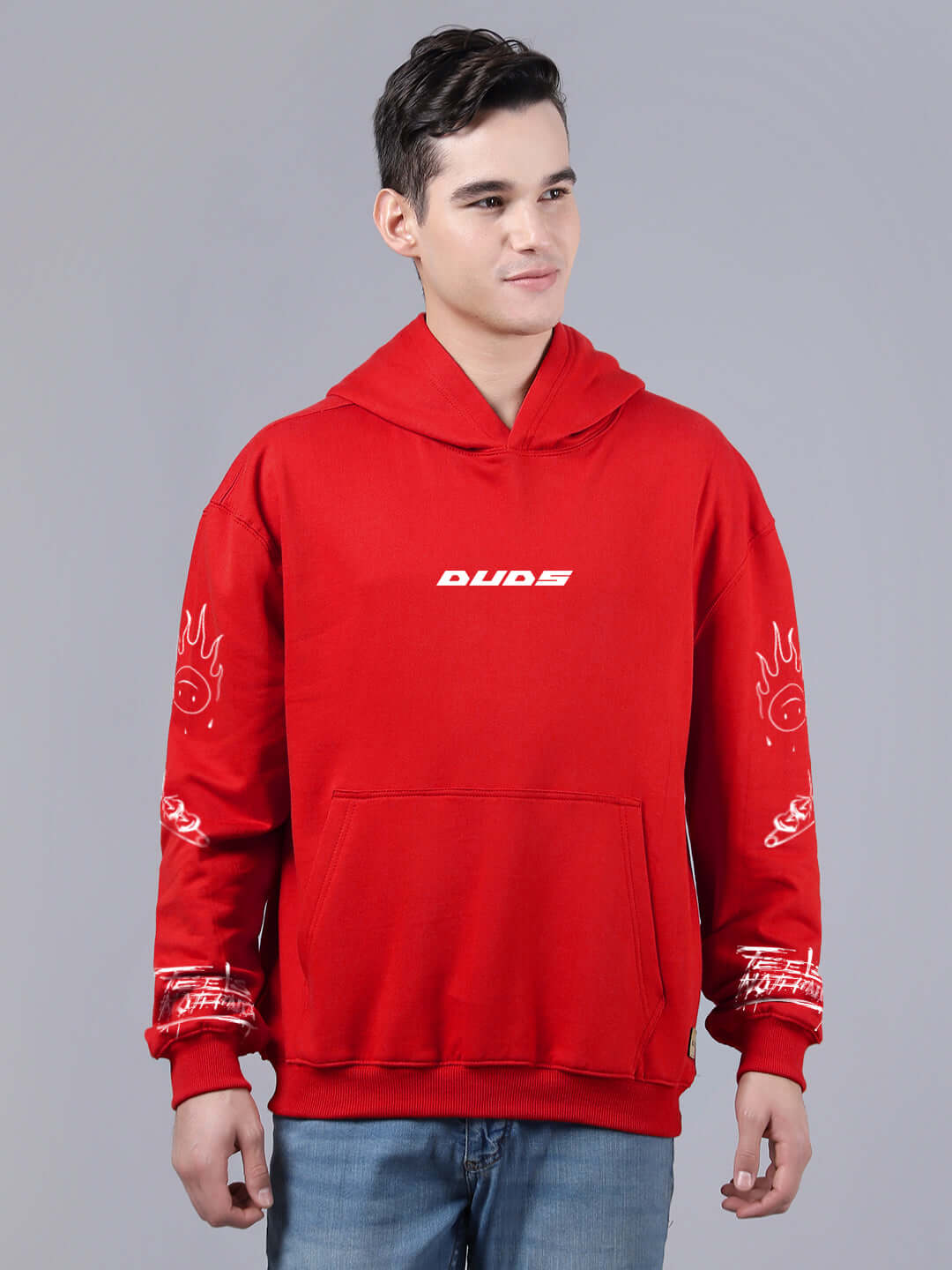 Model wearing an oversized red hoodie with graphic designs on sleeves, front view. Casual fashion, streetwear style.