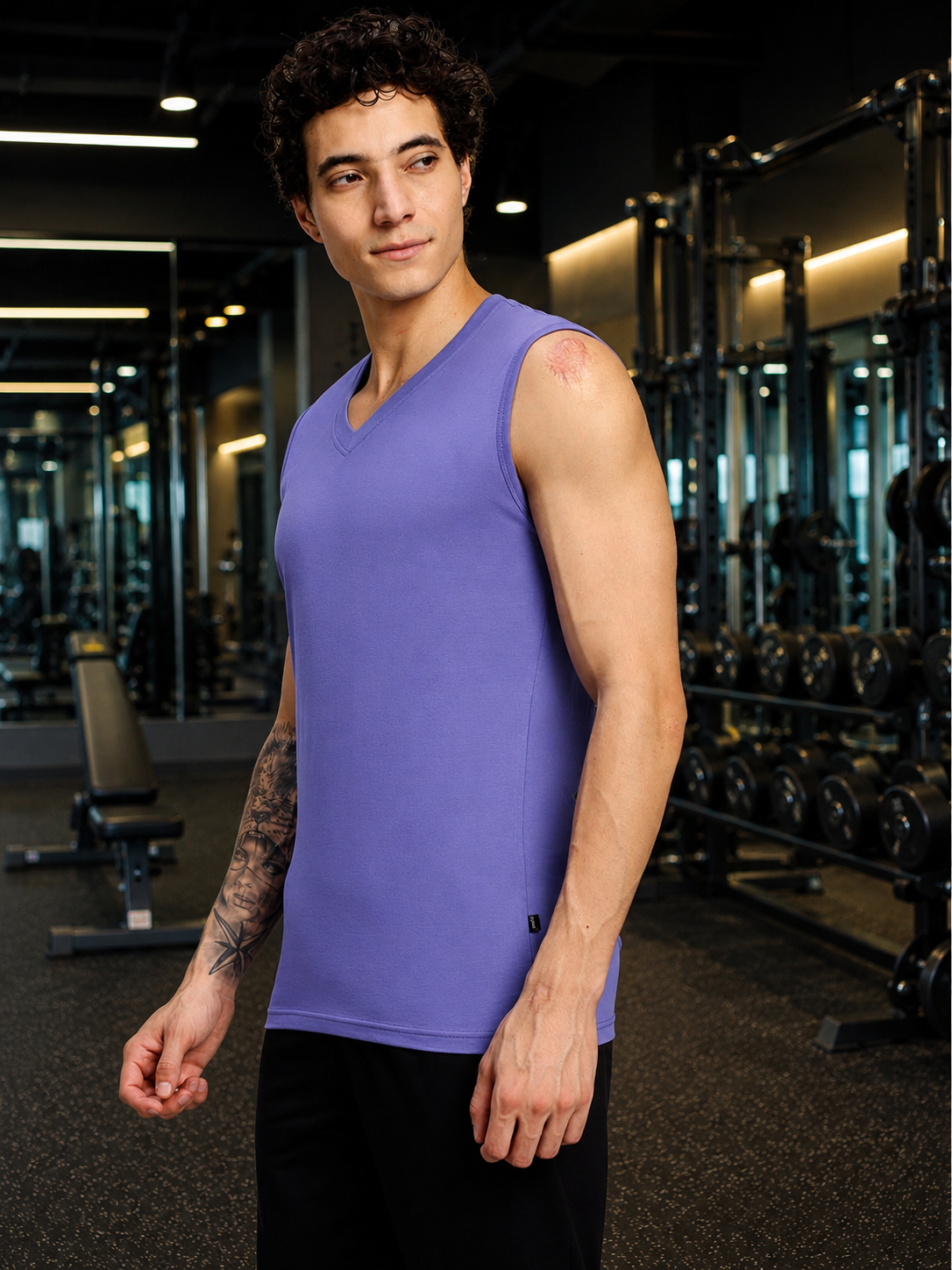 LEVELUP GAMER SLEEVELESS T-SHIRT PURPLE worn by a model in a gym setting, showcasing modern gaming-inspired fashion.